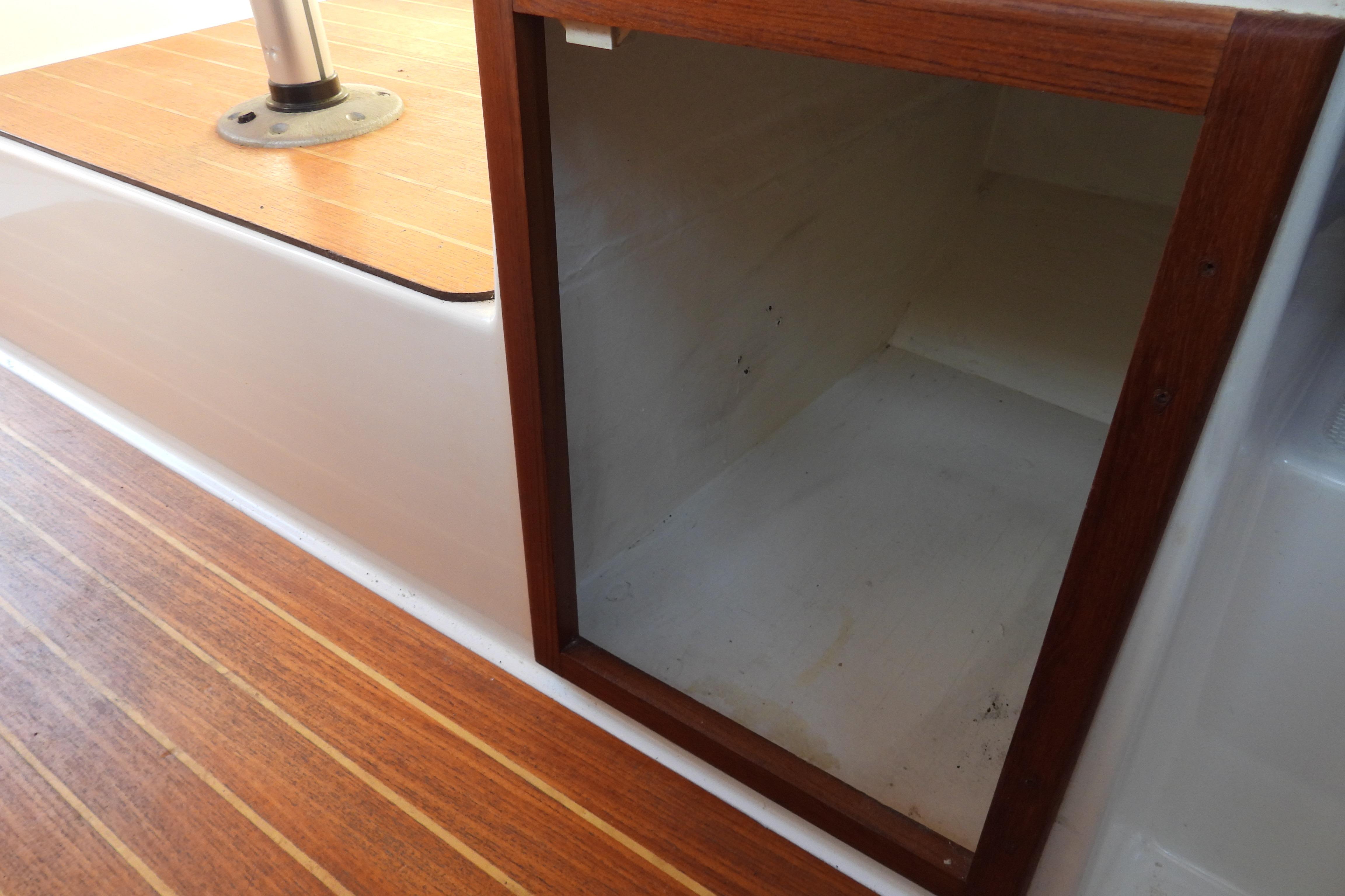 Storage compartment on 2007 Ranger Tug R-25 boat with wooden trim and flooring.