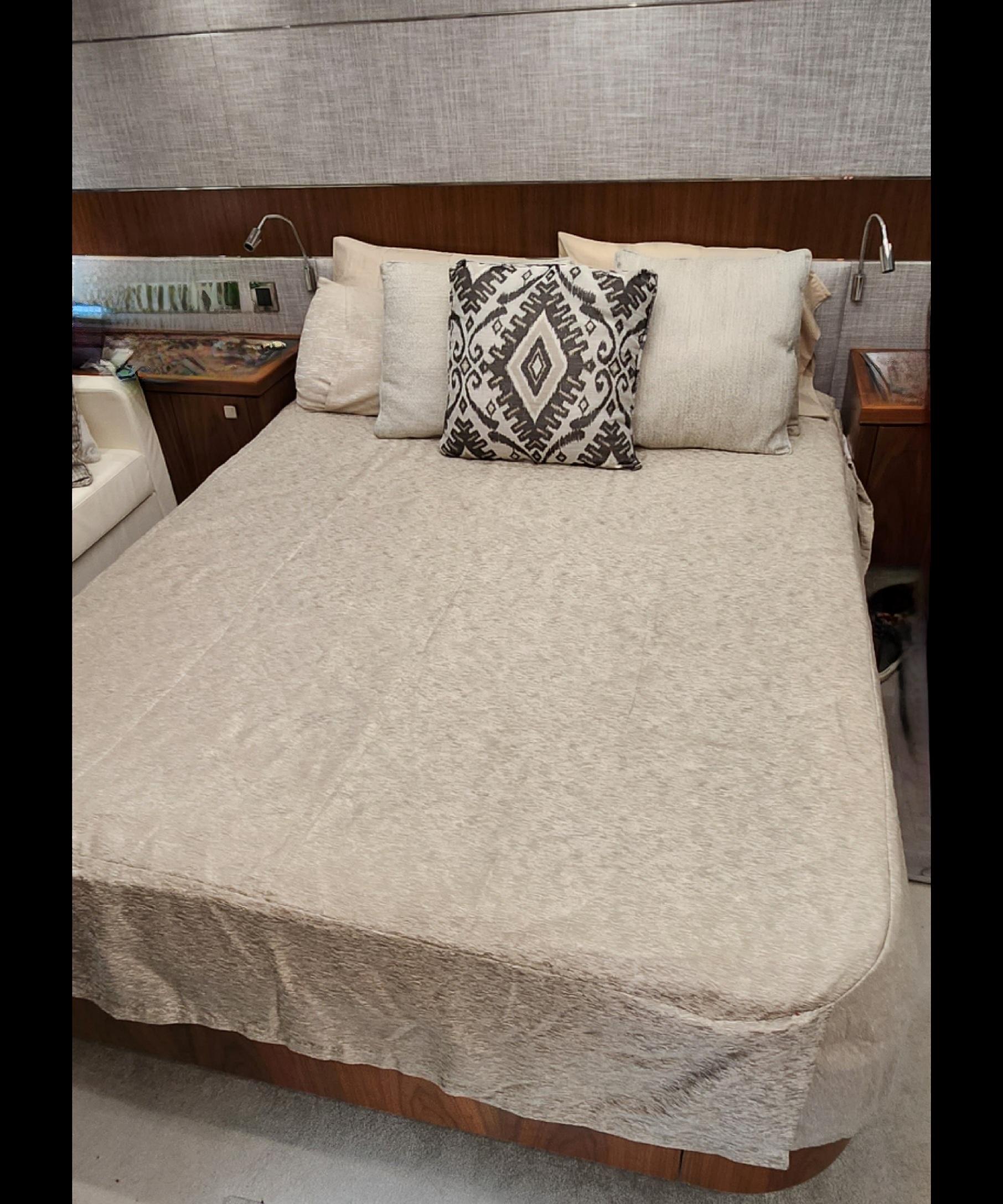 2018 Sunseeker Predator yacht bedroom with beige bedding and decorative pillows.