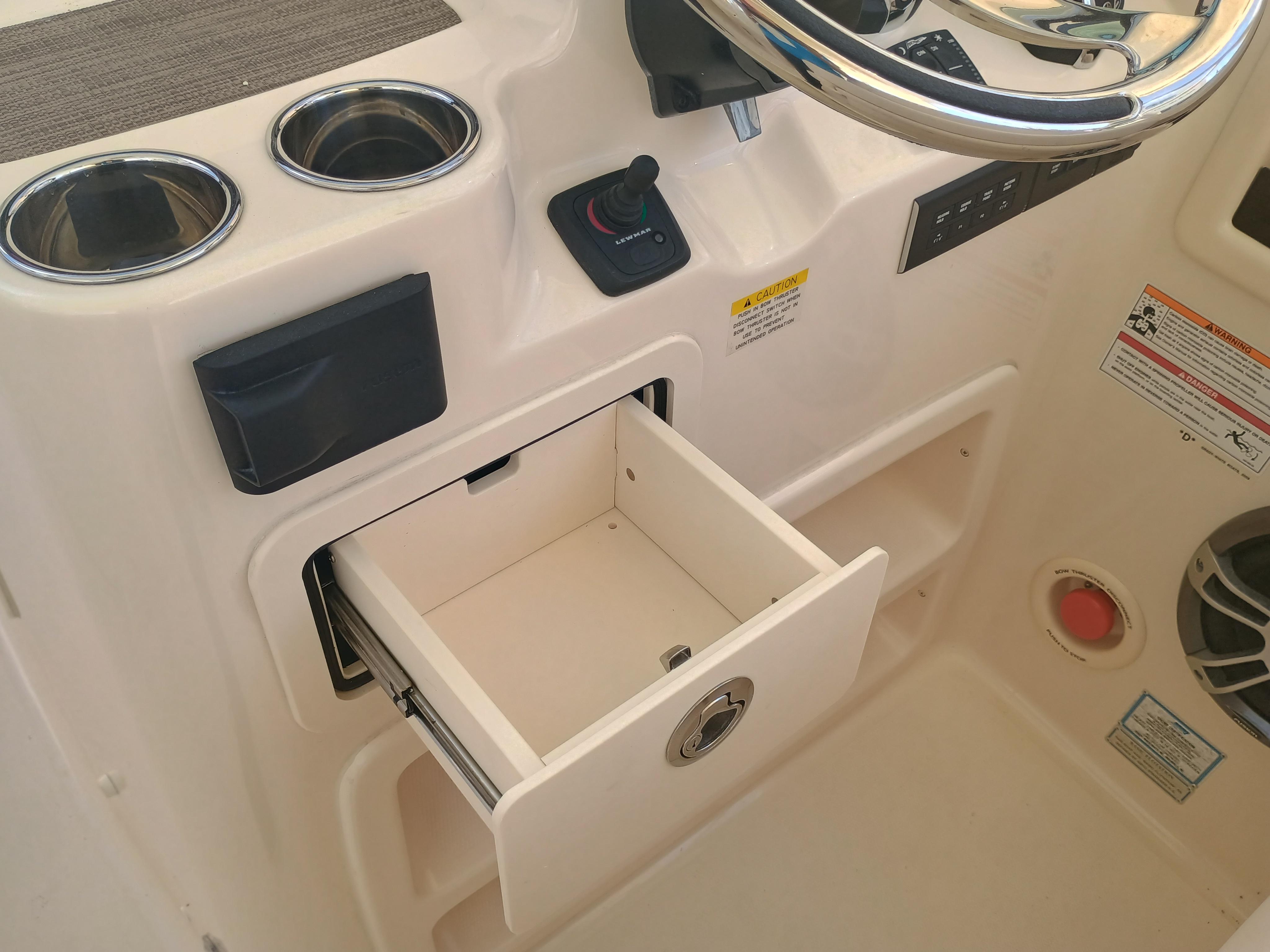 2025 Grady-White Canyon 456 helm with open storage drawer and cup holders.