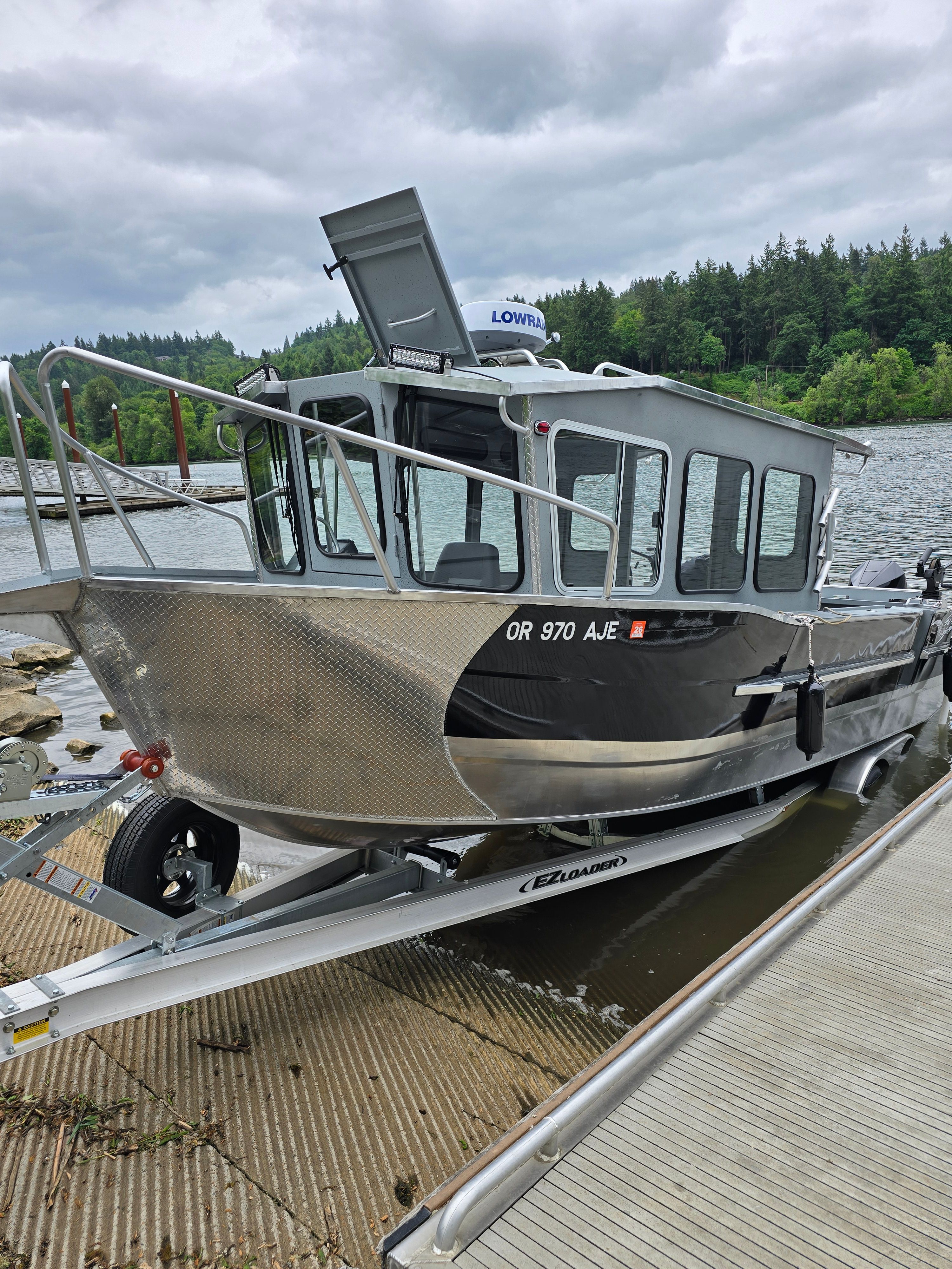 Custom Alaskan Explorer 2025 boat at a lakeside dock.