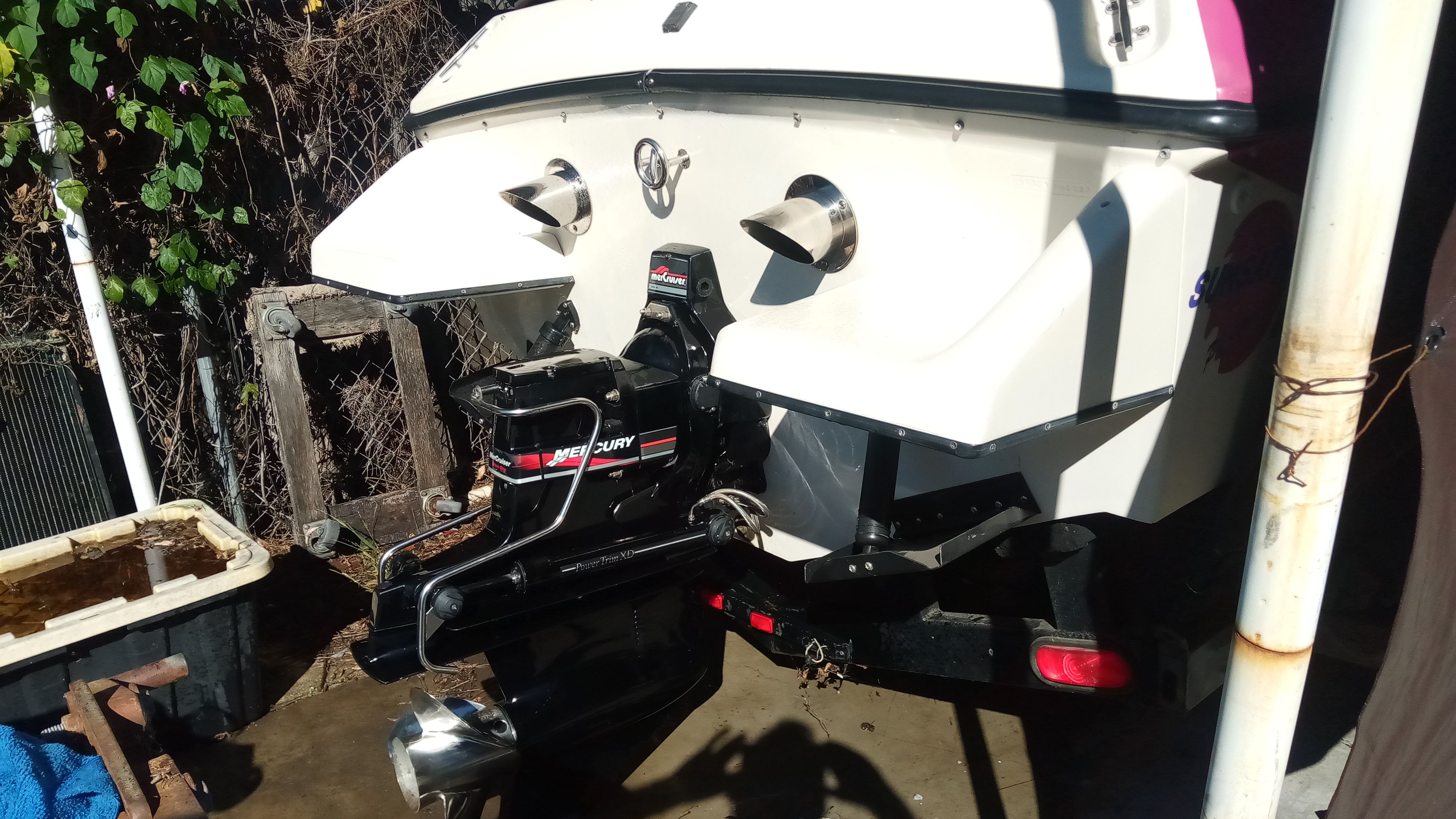Rear view of a 1993 Sunsation Aggressor boat with Mercury drive.