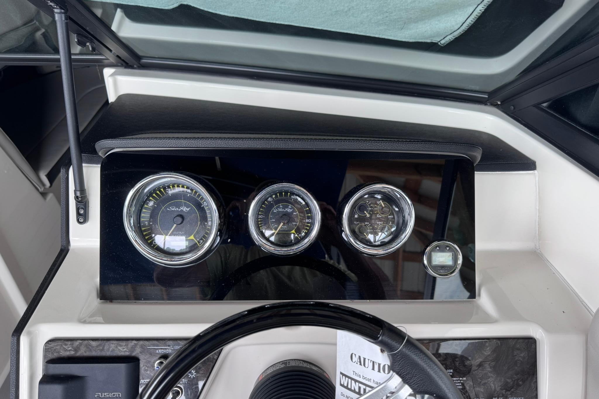 Dashboard of a 2021 Sea Ray SPX 230 boat with gauges and steering wheel.