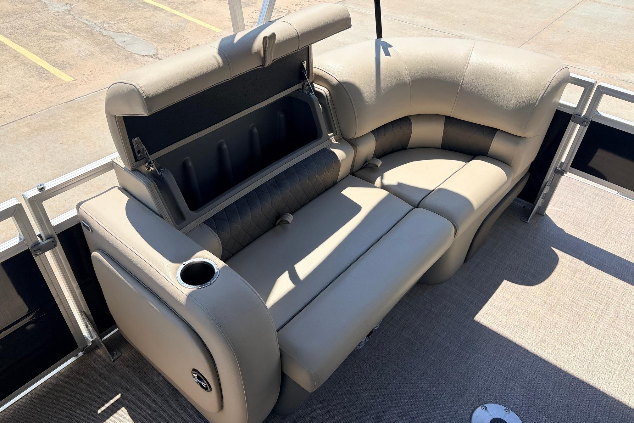 2024 Sun Tracker SportFish 22 XP3 pontoon boat with plush seating and storage compartment.