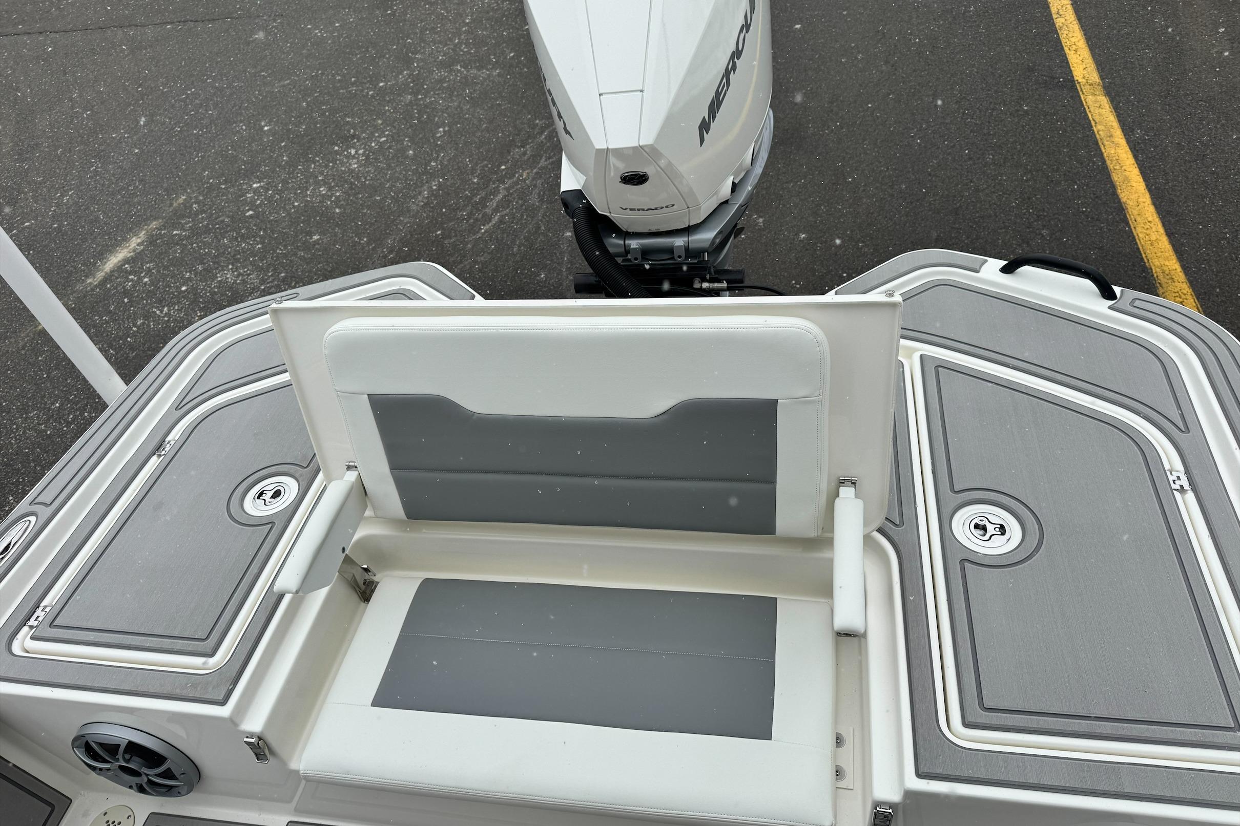 2026 Mako 24 APEX boat with Mercury engine, featuring sleek seating and storage compartments.