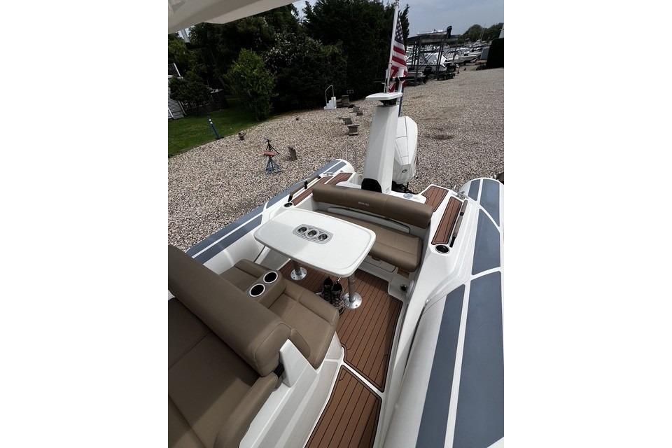 2022 Brig Eagle 8 boat interior with seating and table, docked outdoors.