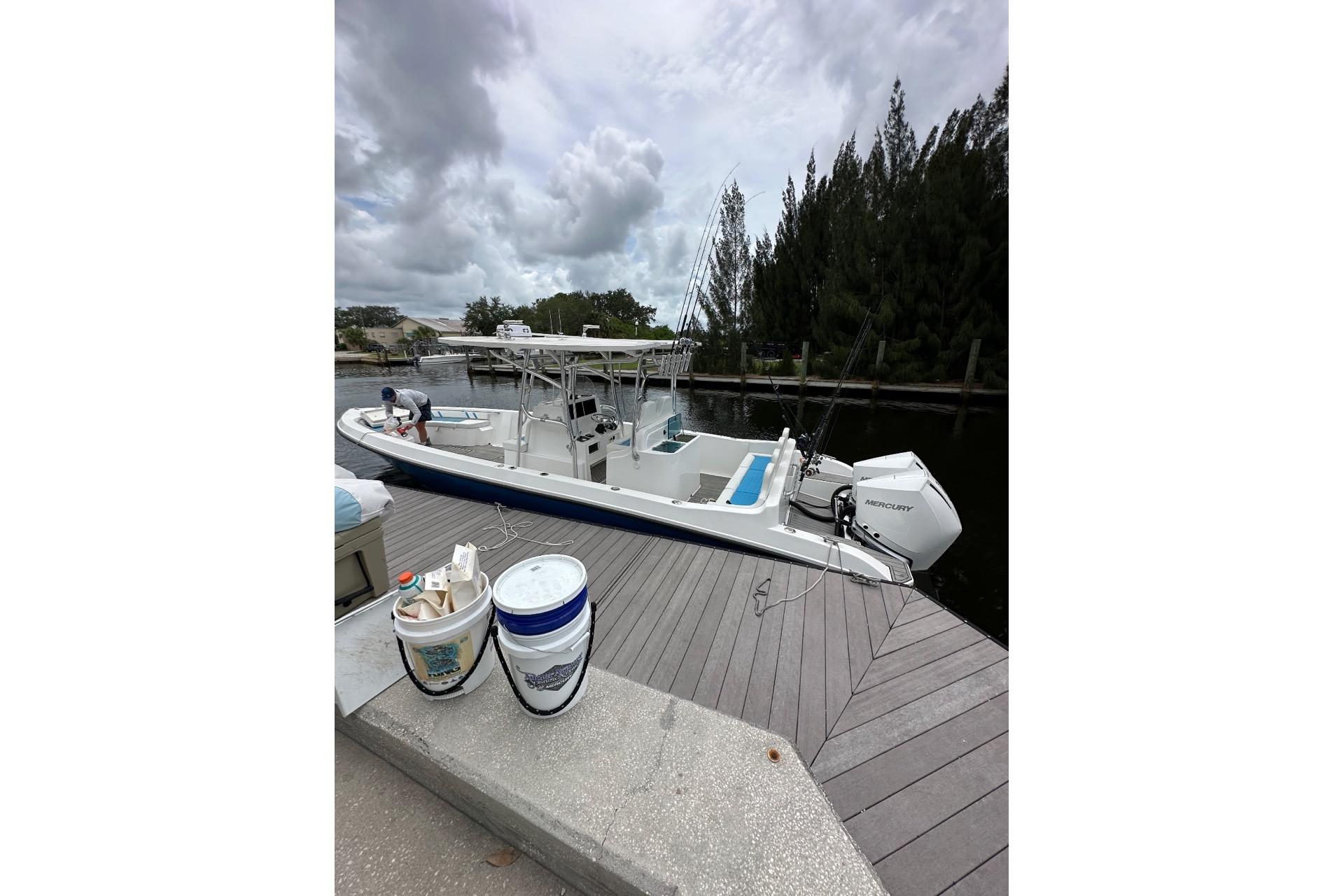 Custom Infusion 34 CC boat docked, 2021 model, with fishing gear and cloudy sky.