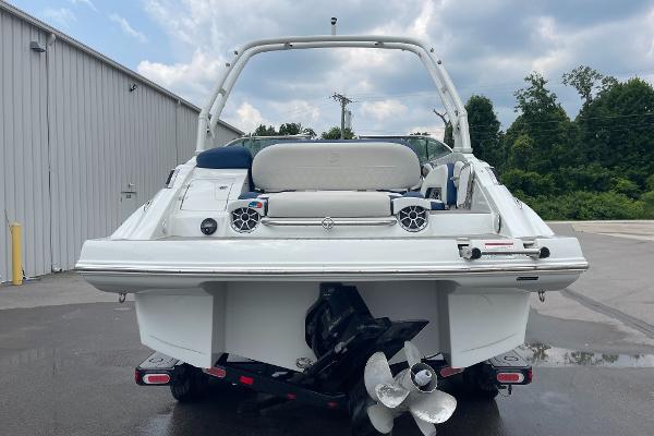 2023 Crownline E235 boat, rear view, showcasing propeller and seating, parked outdoors.
