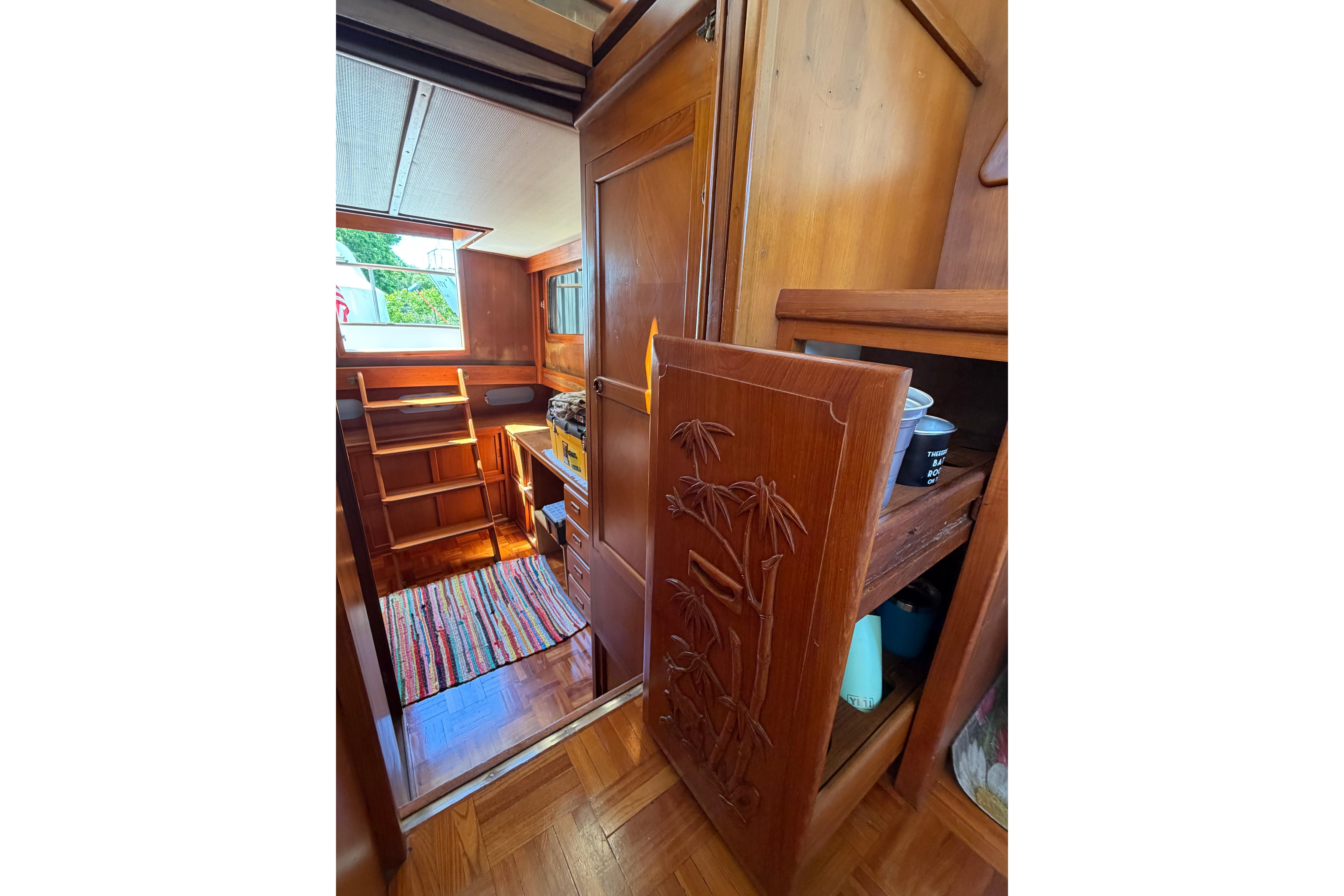 Interior of 1987 Marine Trader 36 boat with wooden cabinetry and colorful rug.