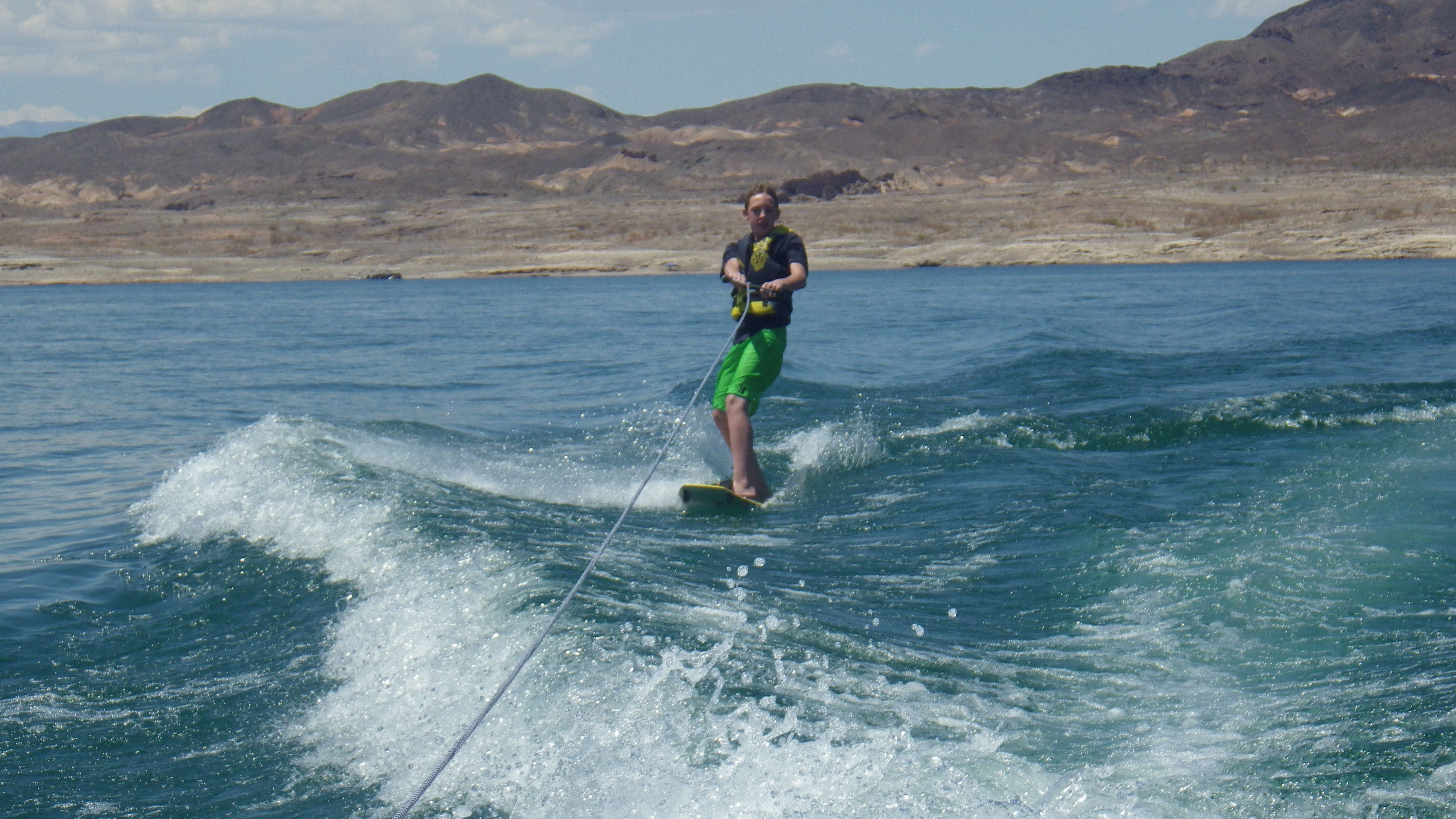 Person wakeboarding behind a 2008 Four Winns H220SS boat.
