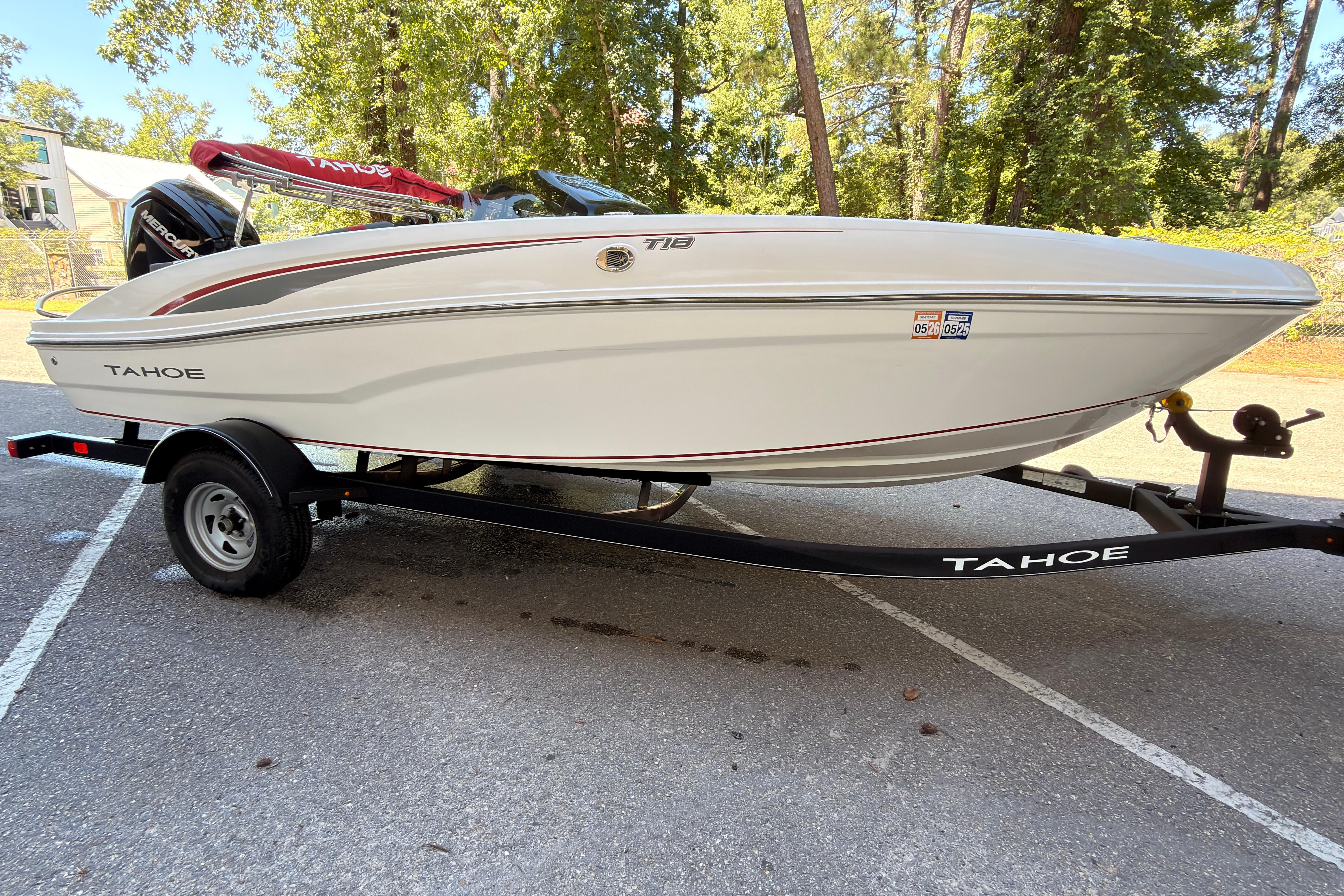2022 Tahoe T18 boat on trailer, parked outdoors with trees in background.