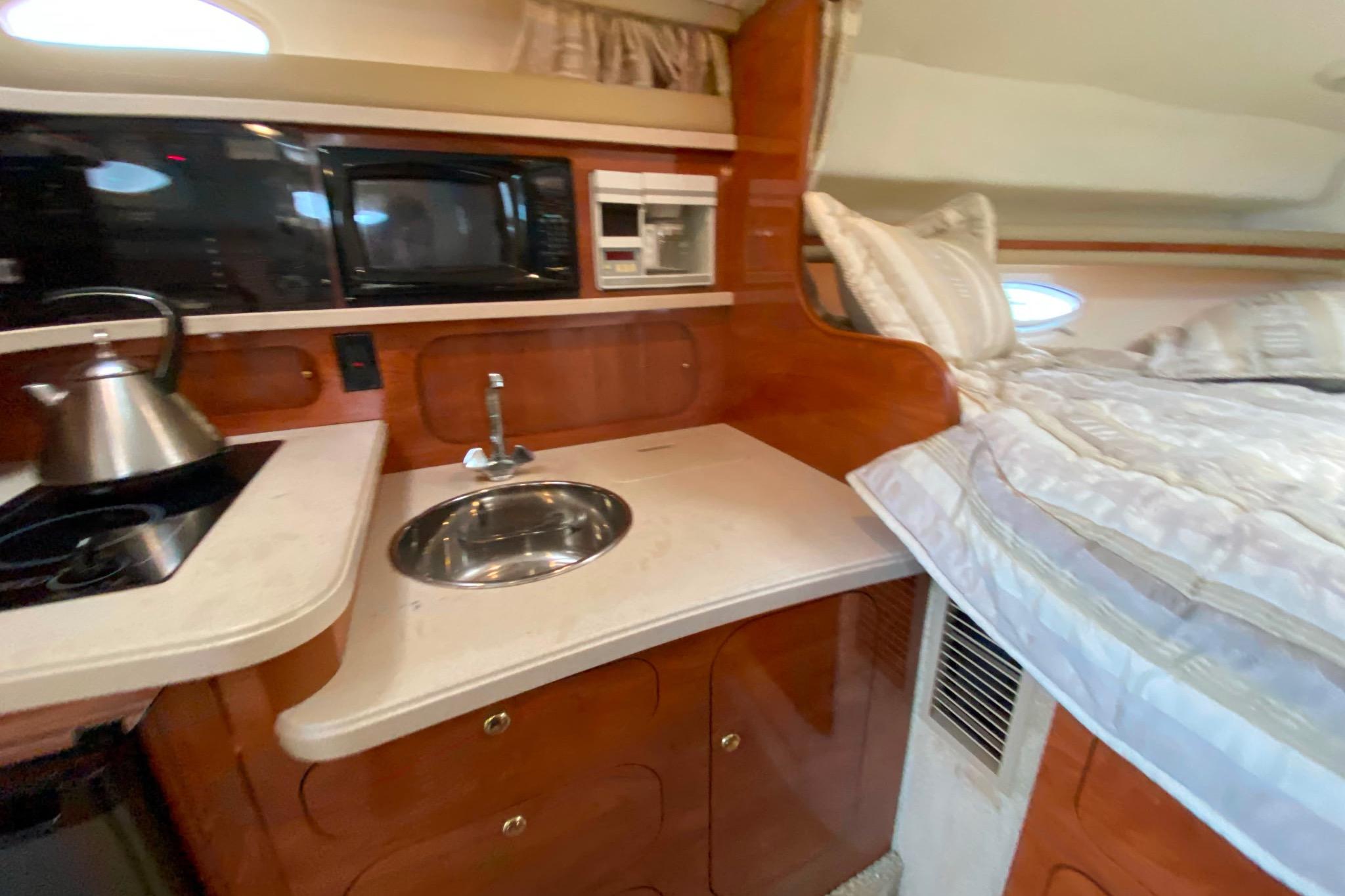 2003 Rinker Fiesta Vee 342 interior with kitchenette and bed.