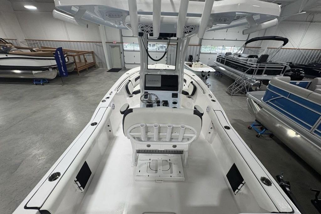 2026 Tidewater 232 CC Adventure boat interior in showroom, featuring helm and seating.