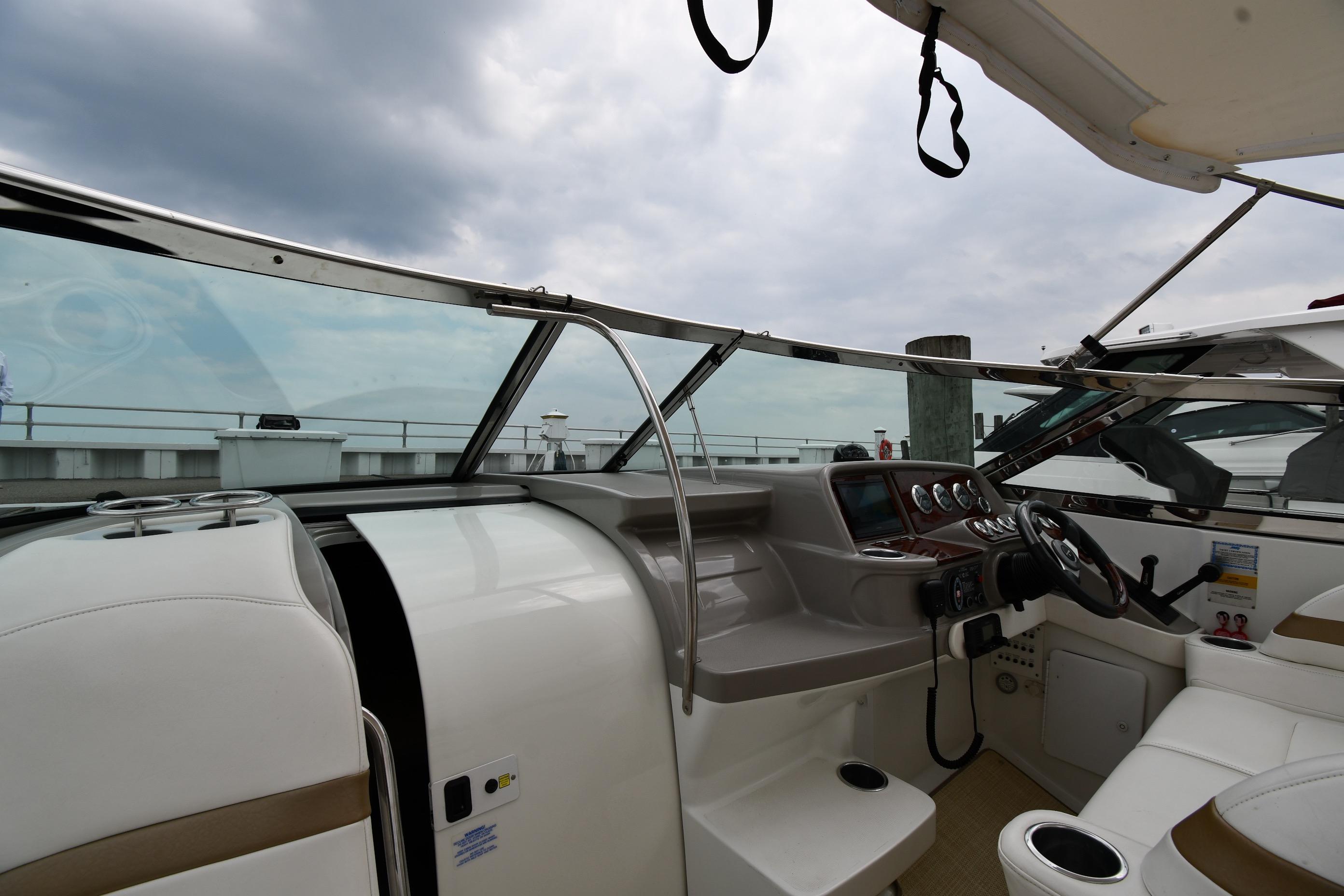 Interior view of 2004 Formula 330 Sun Sport boat cockpit with steering wheel and dashboard.