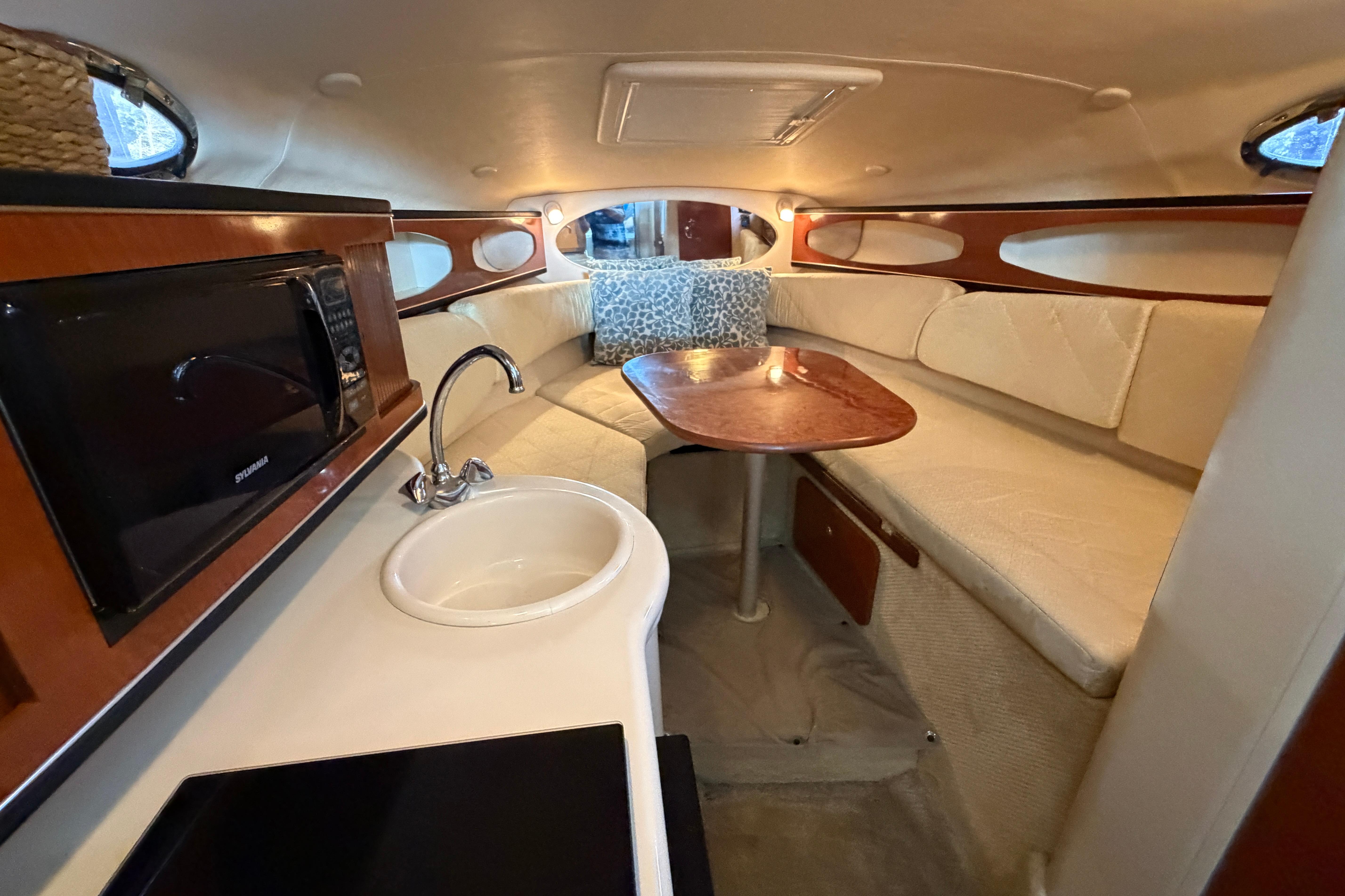 Interior of 2004 Sea Ray Sundancer 260 with kitchenette and seating area.