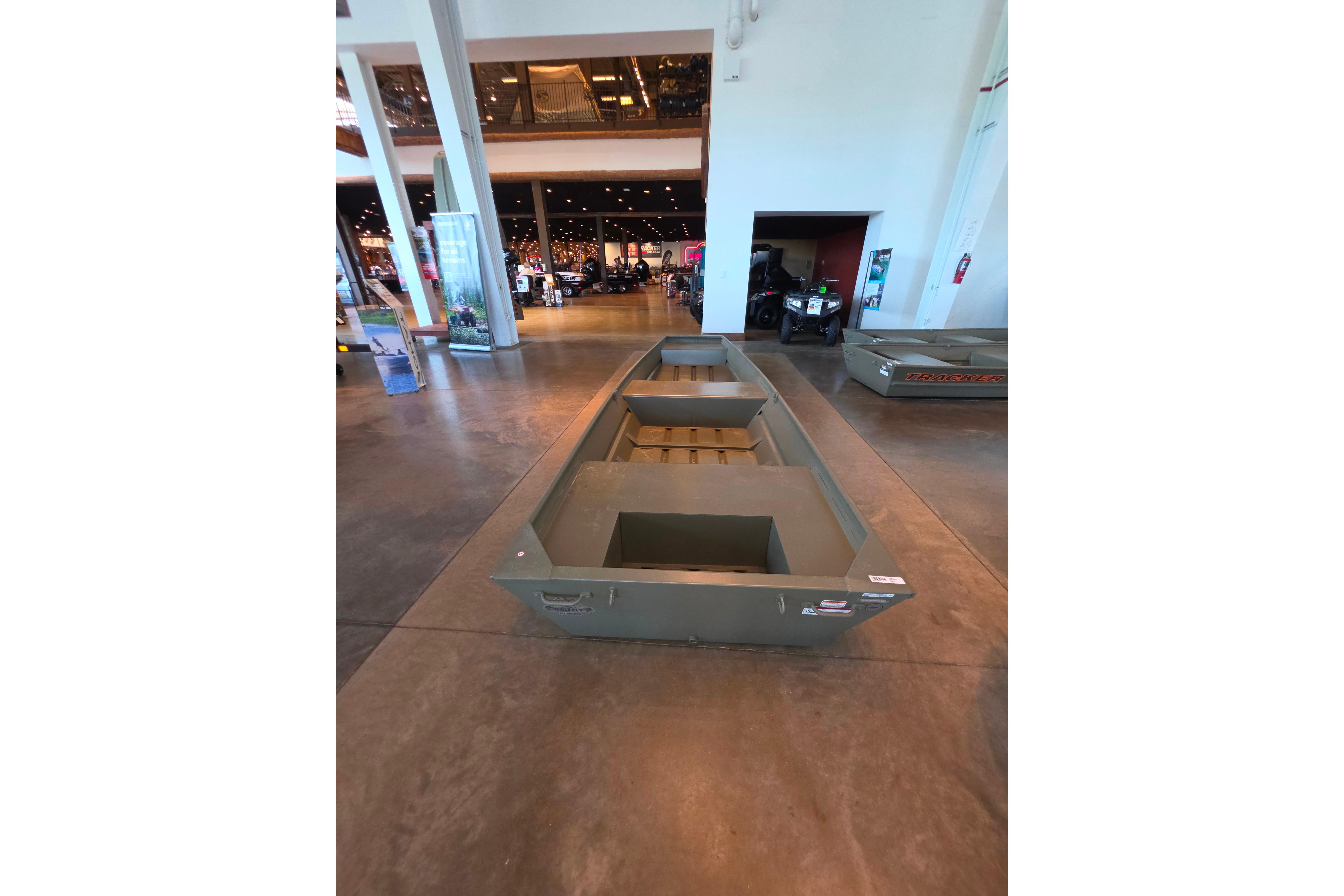 2026 Tracker Grizzly 14 Jon boat displayed indoors on a polished concrete floor.
