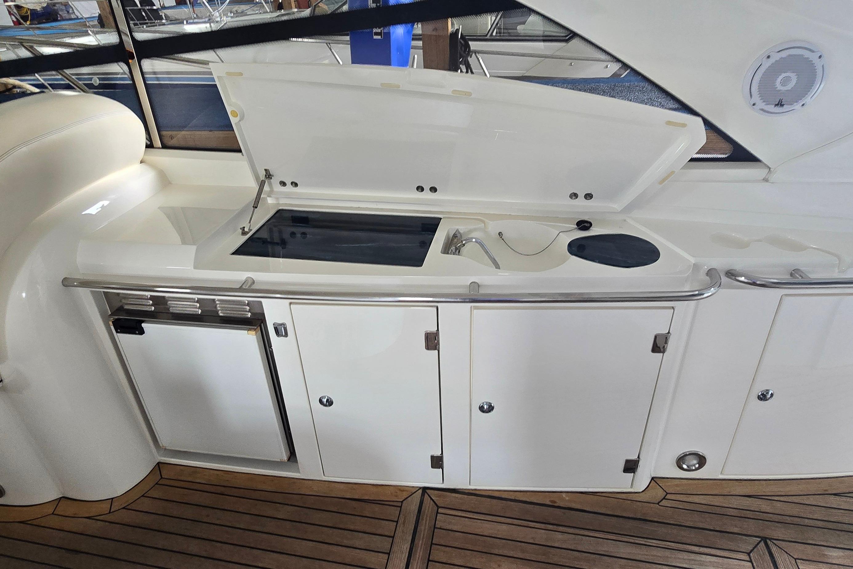 Outdoor kitchenette on a 2004 Sunseeker Camargue 50 yacht with sink and storage.