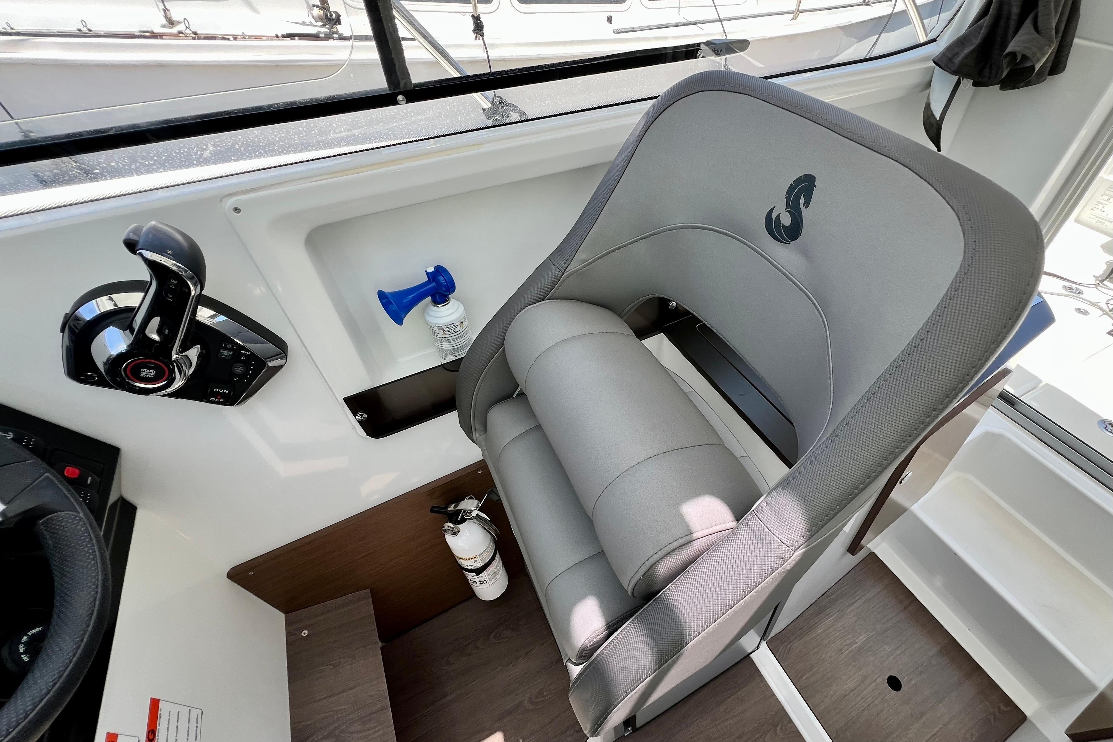 Captain's seat and controls in a 2023 Beneteau Antares 8 boat cockpit.