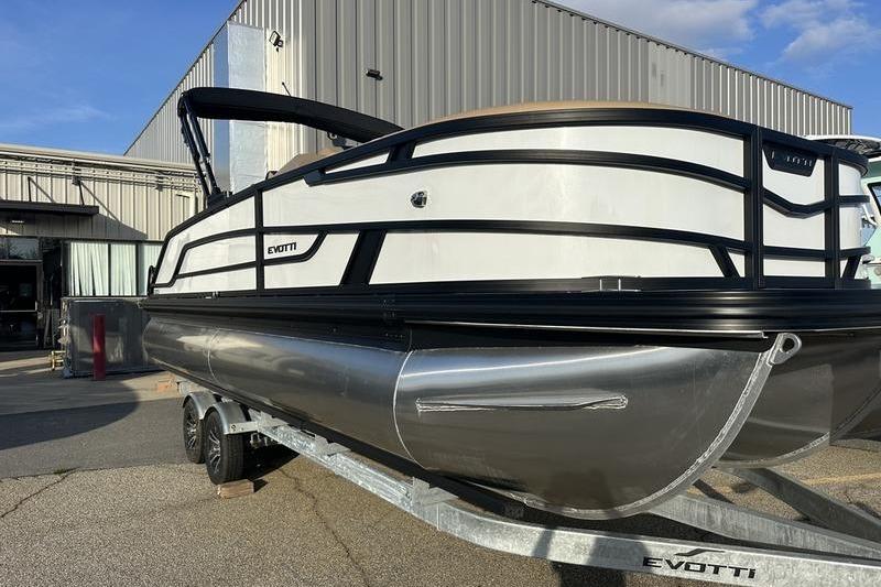 2026 Evotti 523CS pontoon boat on trailer, parked outside industrial building.