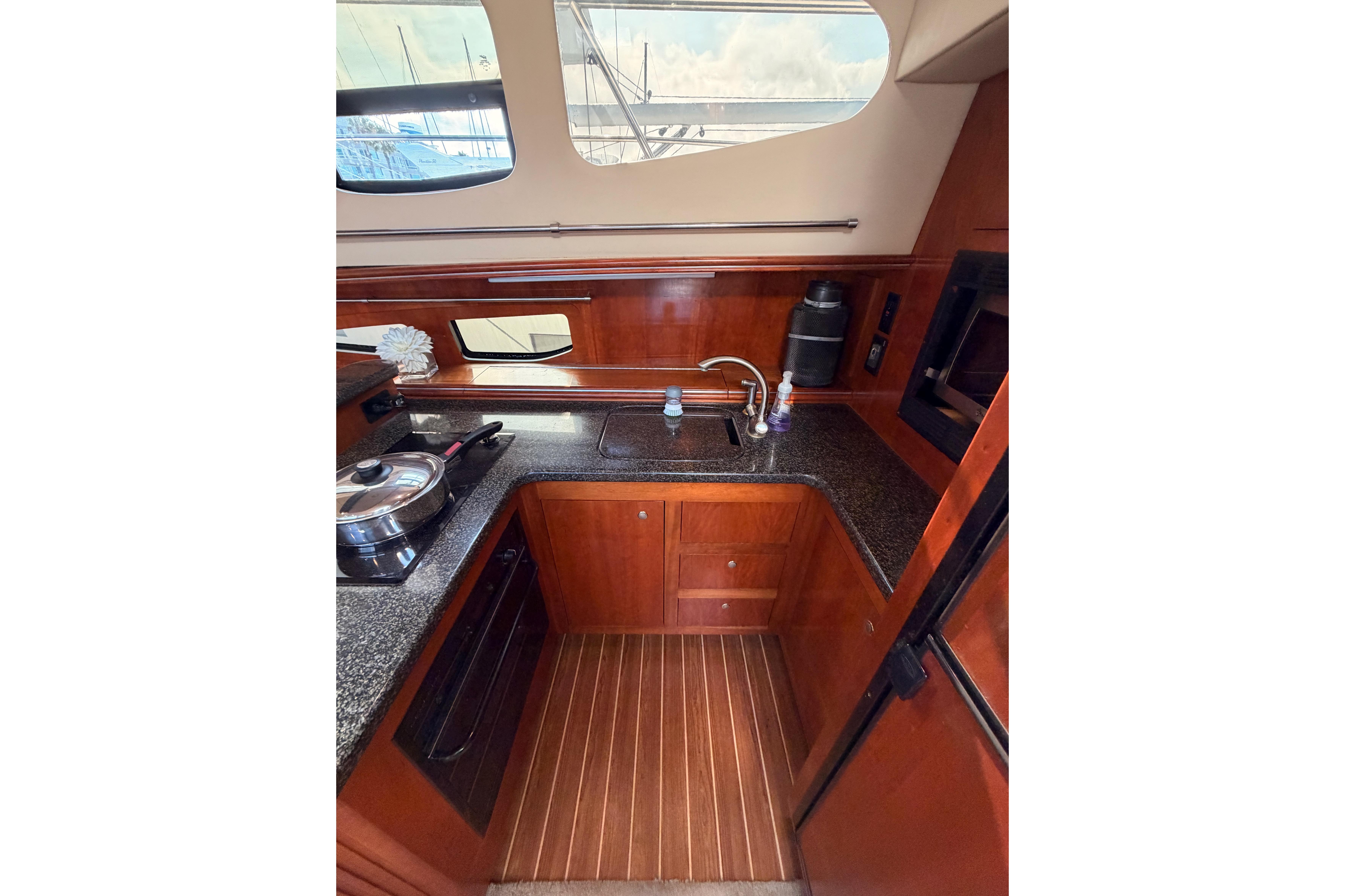 Luxurious 2005 Cruisers Yachts 405 Express Motoryacht kitchen with wood cabinetry and modern appliances.
