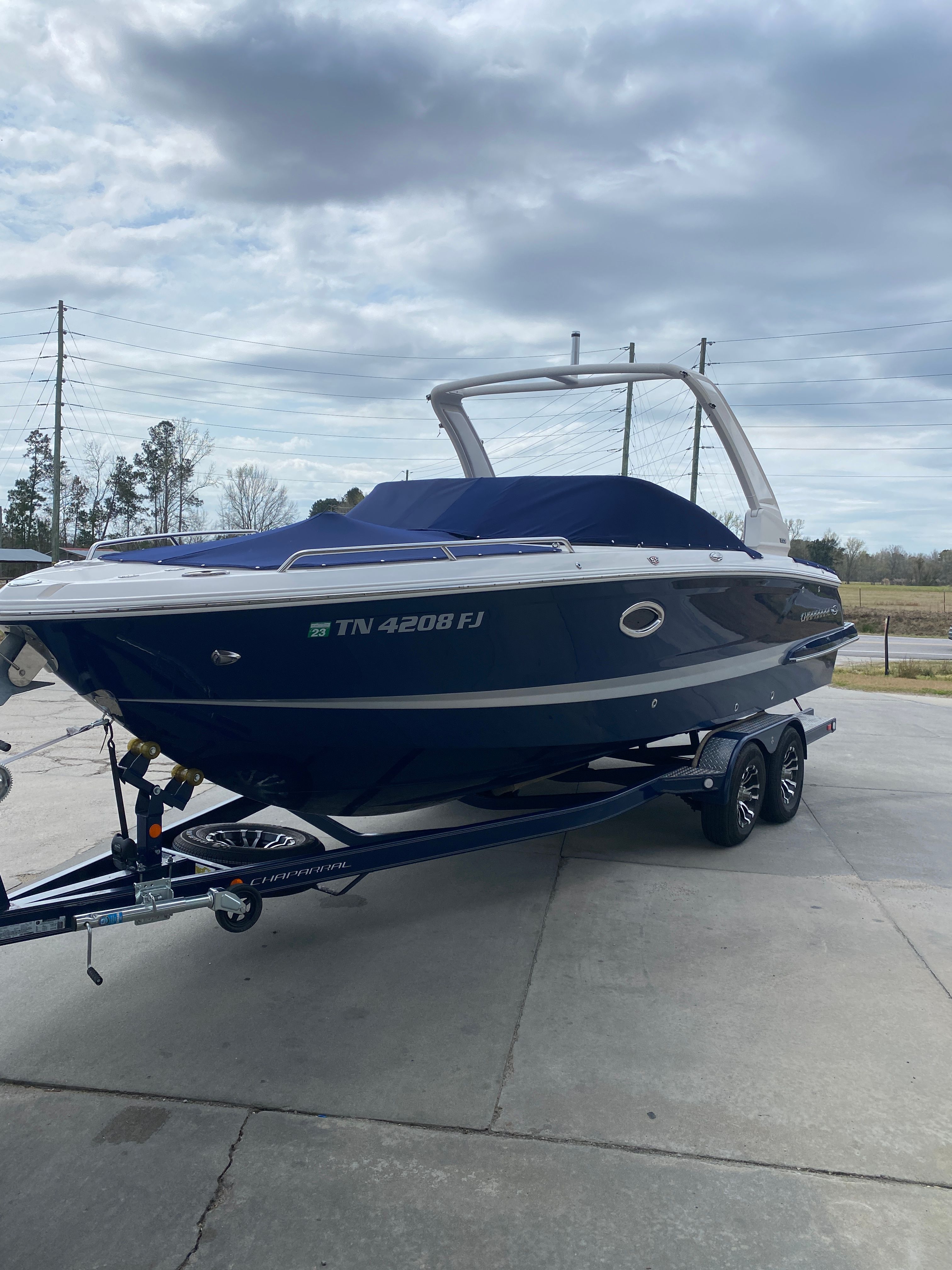 2020 Chaparral 256 SSX boat on trailer, blue hull, cloudy sky.