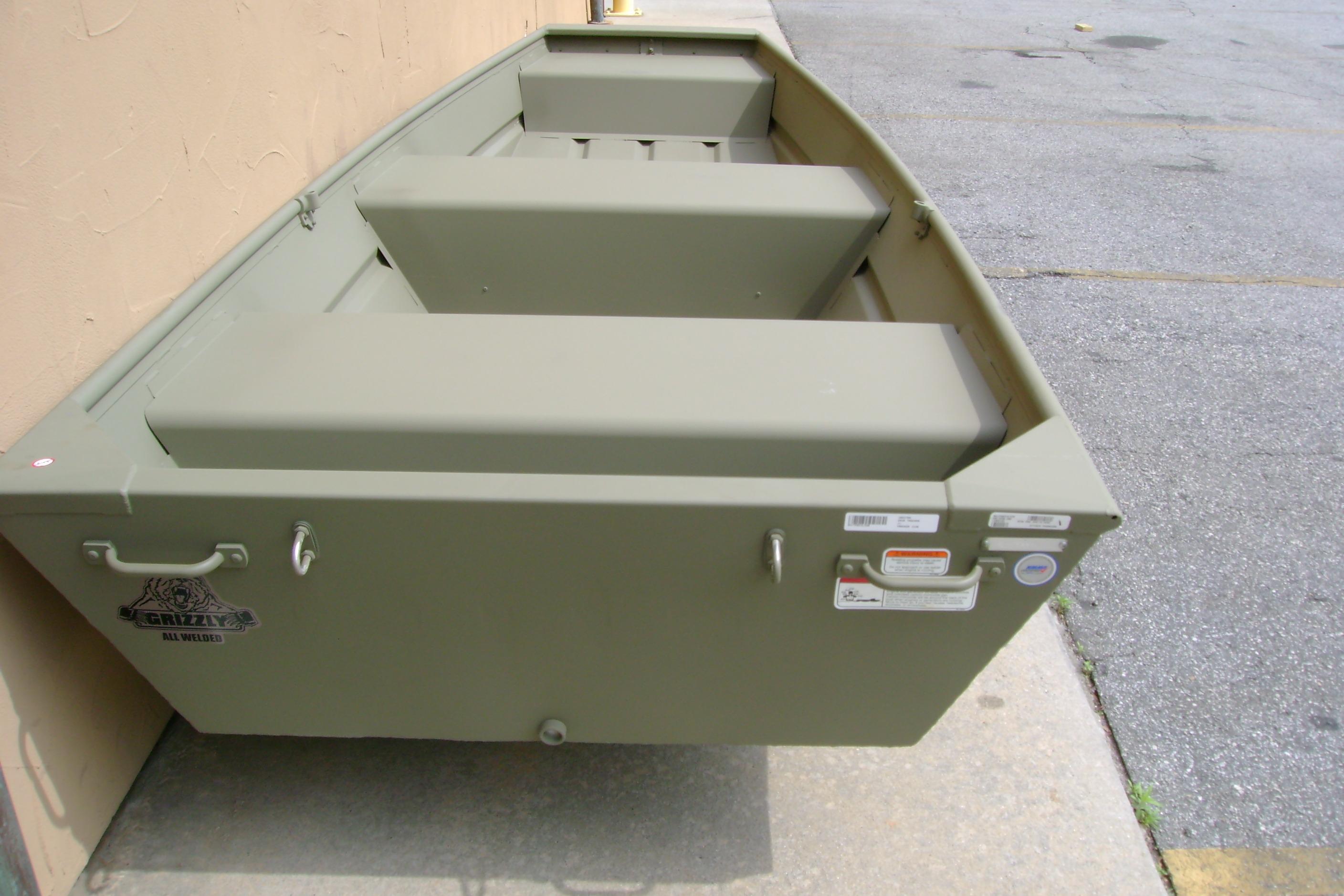 2026 Tracker Grizzly 12 Jon boat in olive green, parked on concrete surface.