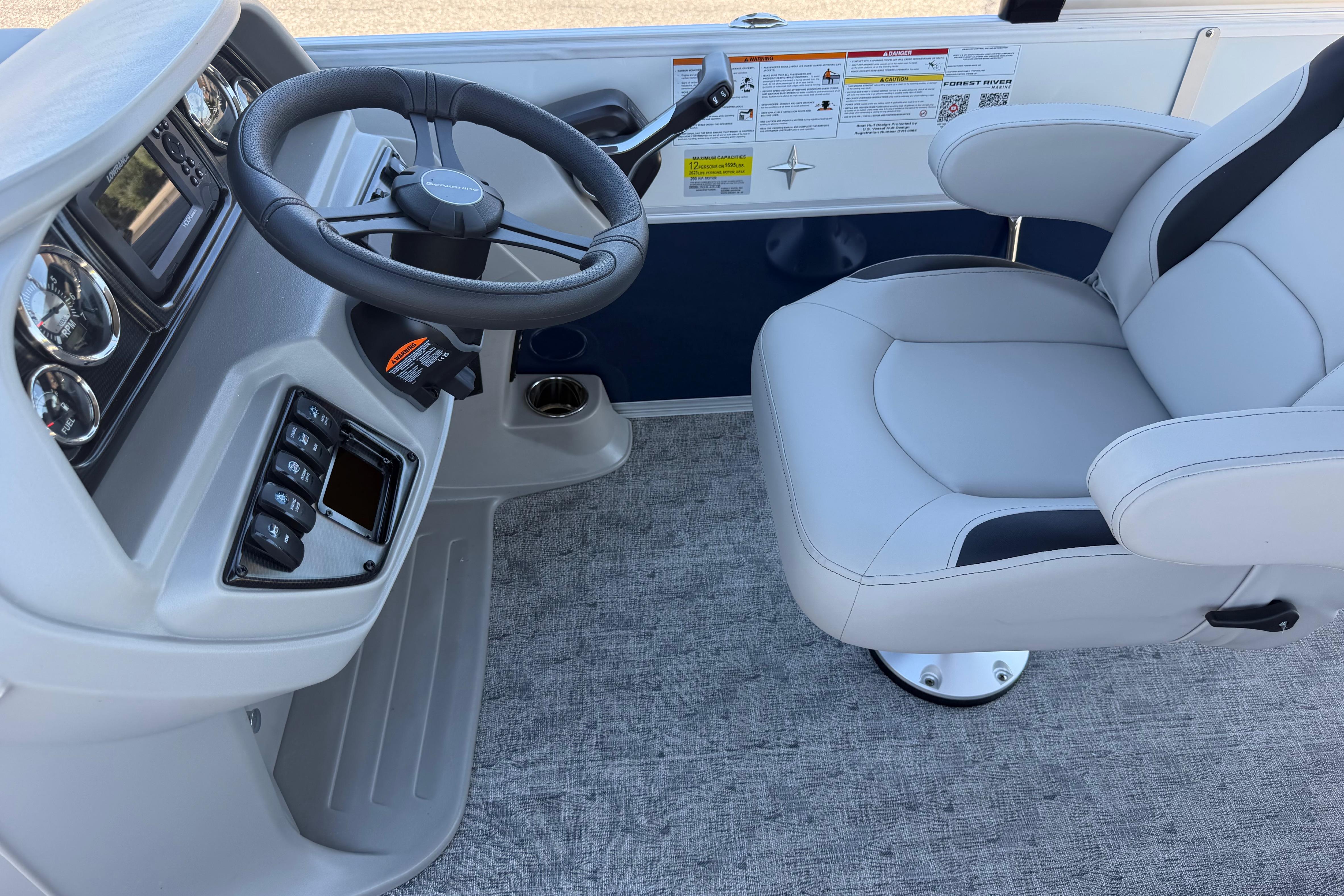 2026 Berkshire LE 24' Ultra Lounger boat helm with steering wheel and captain's chair.
