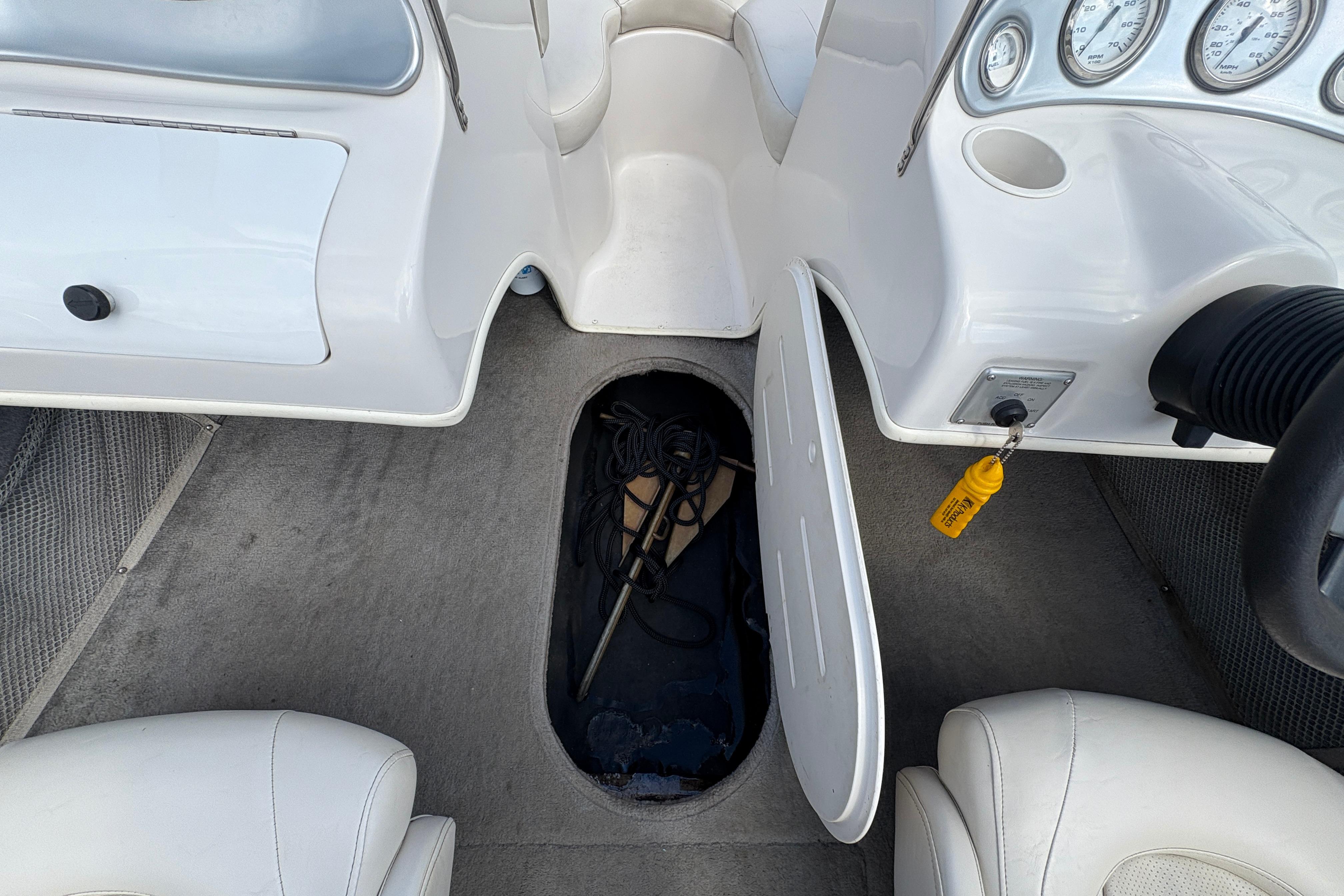 2005 Starcraft C-Star 1700 OB boat interior with open storage compartment and dashboard view.