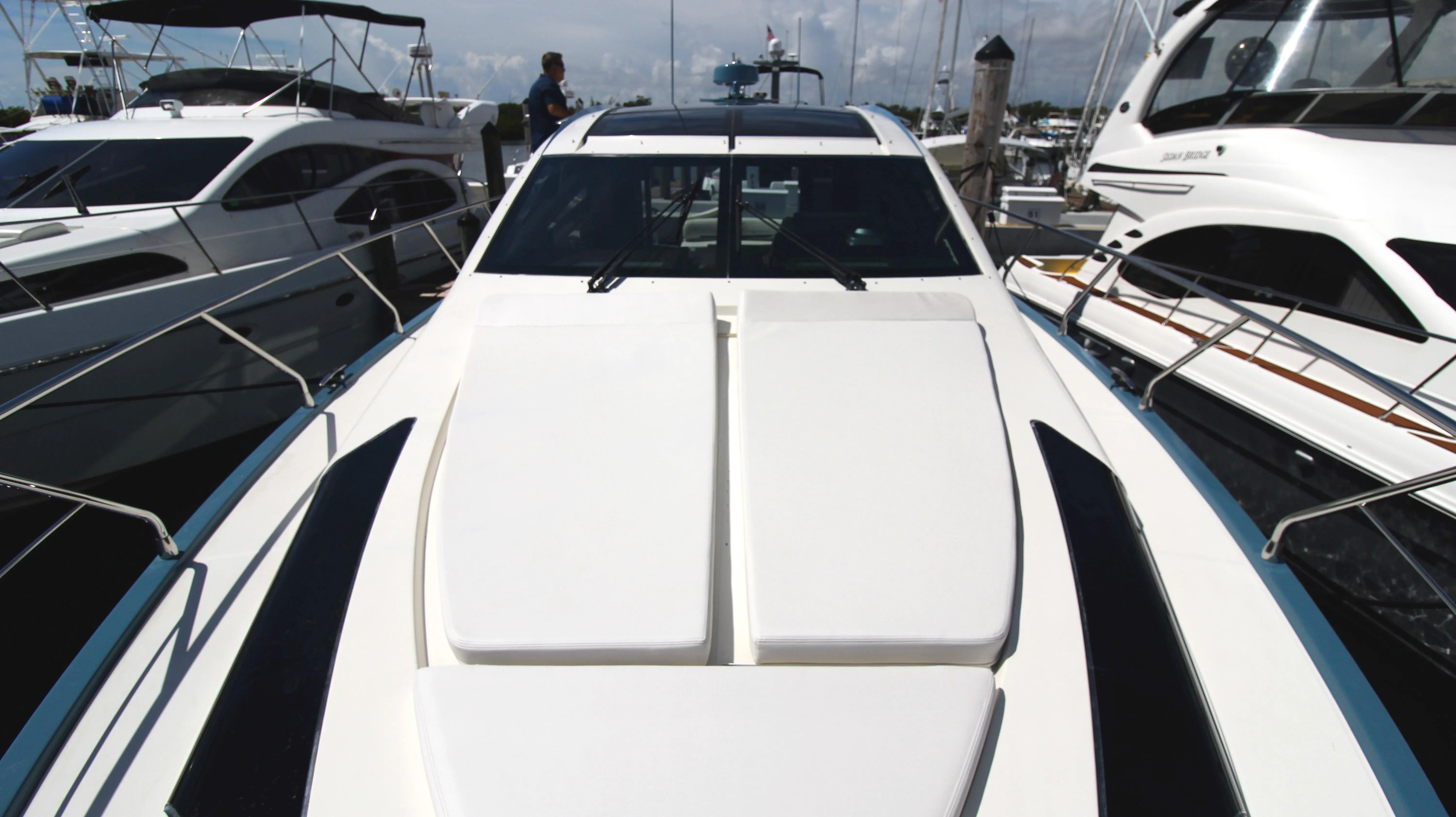 A 2010 Marquis Sport Coupe docked at a marina, surrounded by other boats.