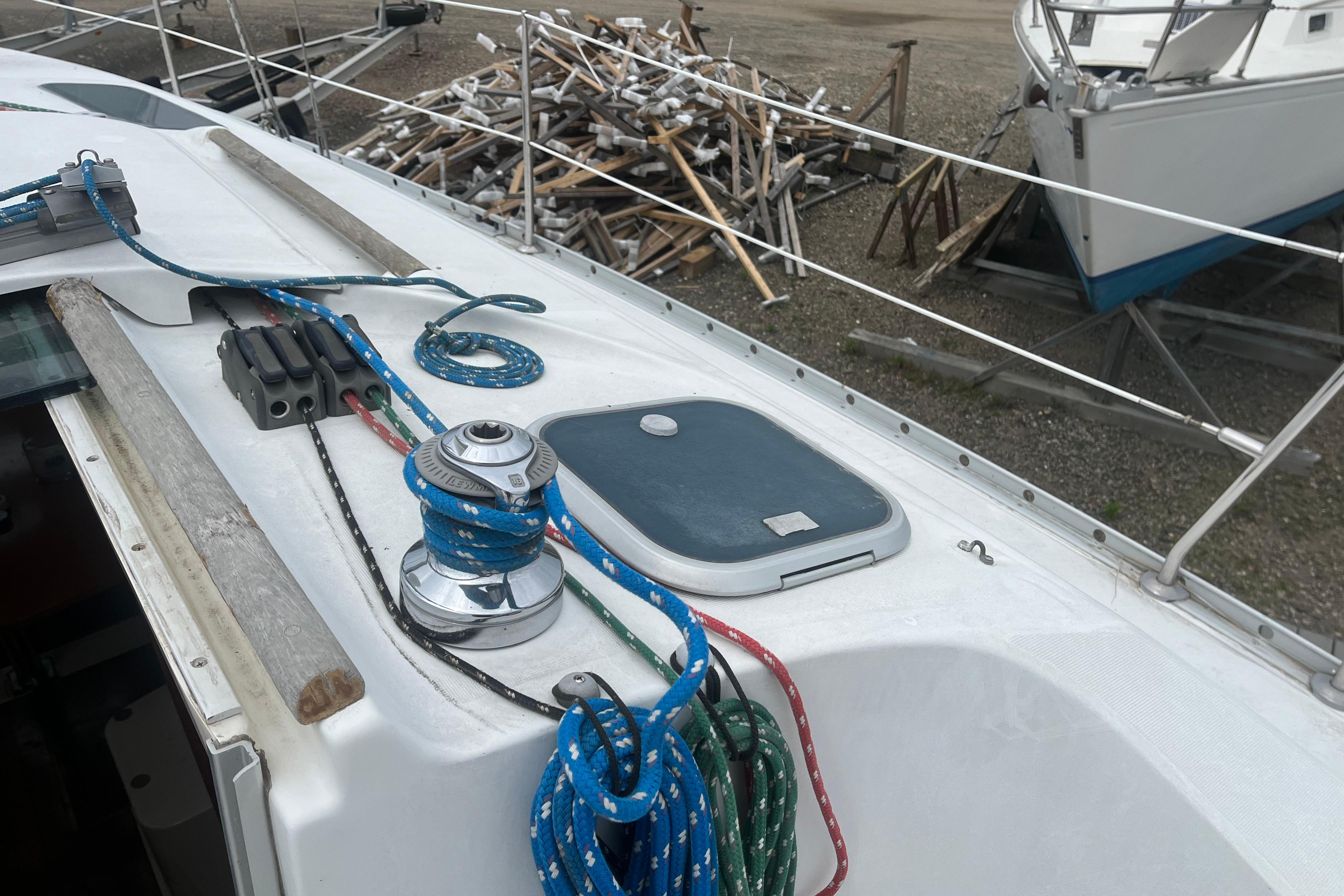 Deck of 1999 Beneteau Oceanis 321 sailboat with winch and ropes.