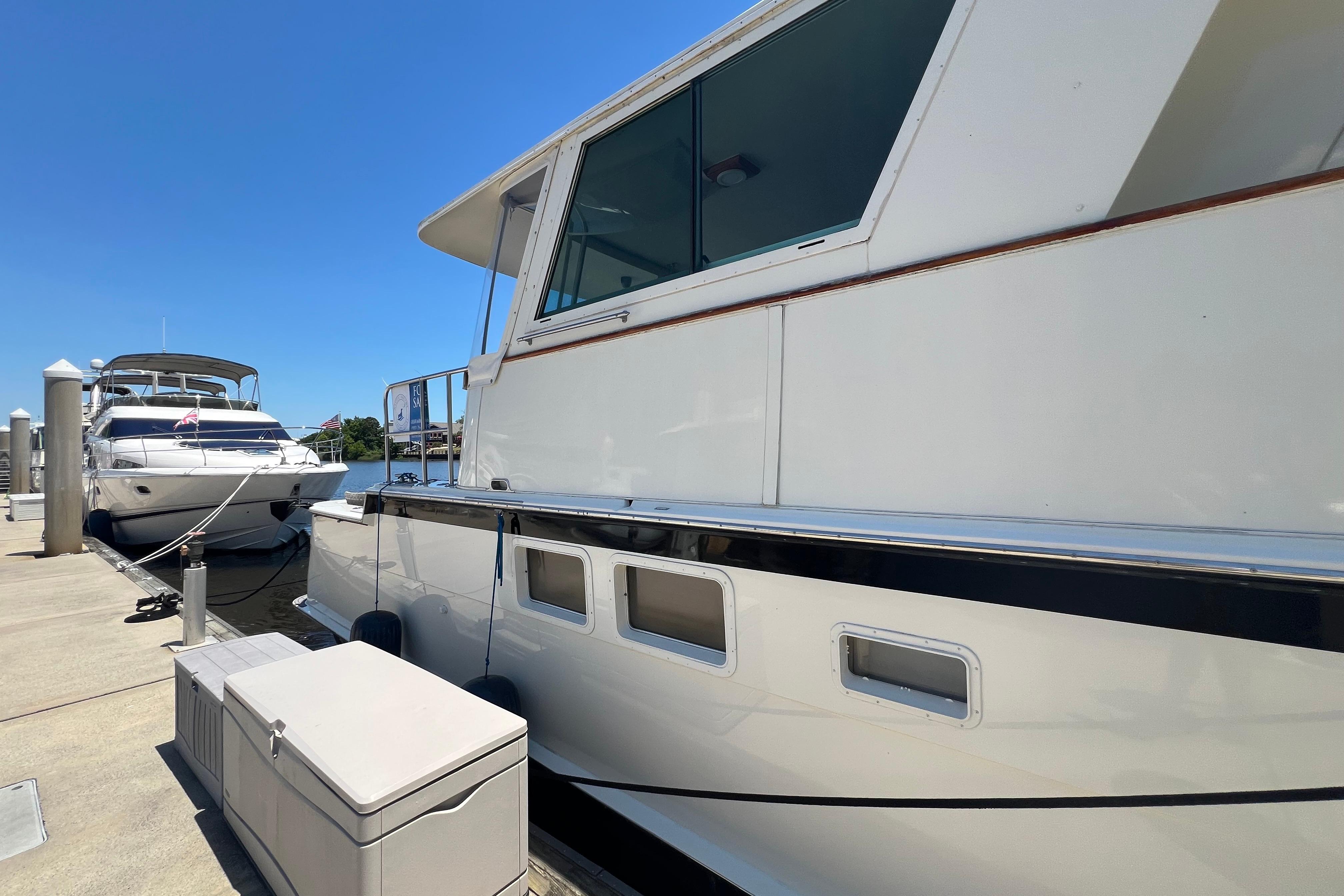 1987 Hatteras 70 Cockpit Motor Yacht docked under clear blue sky.
