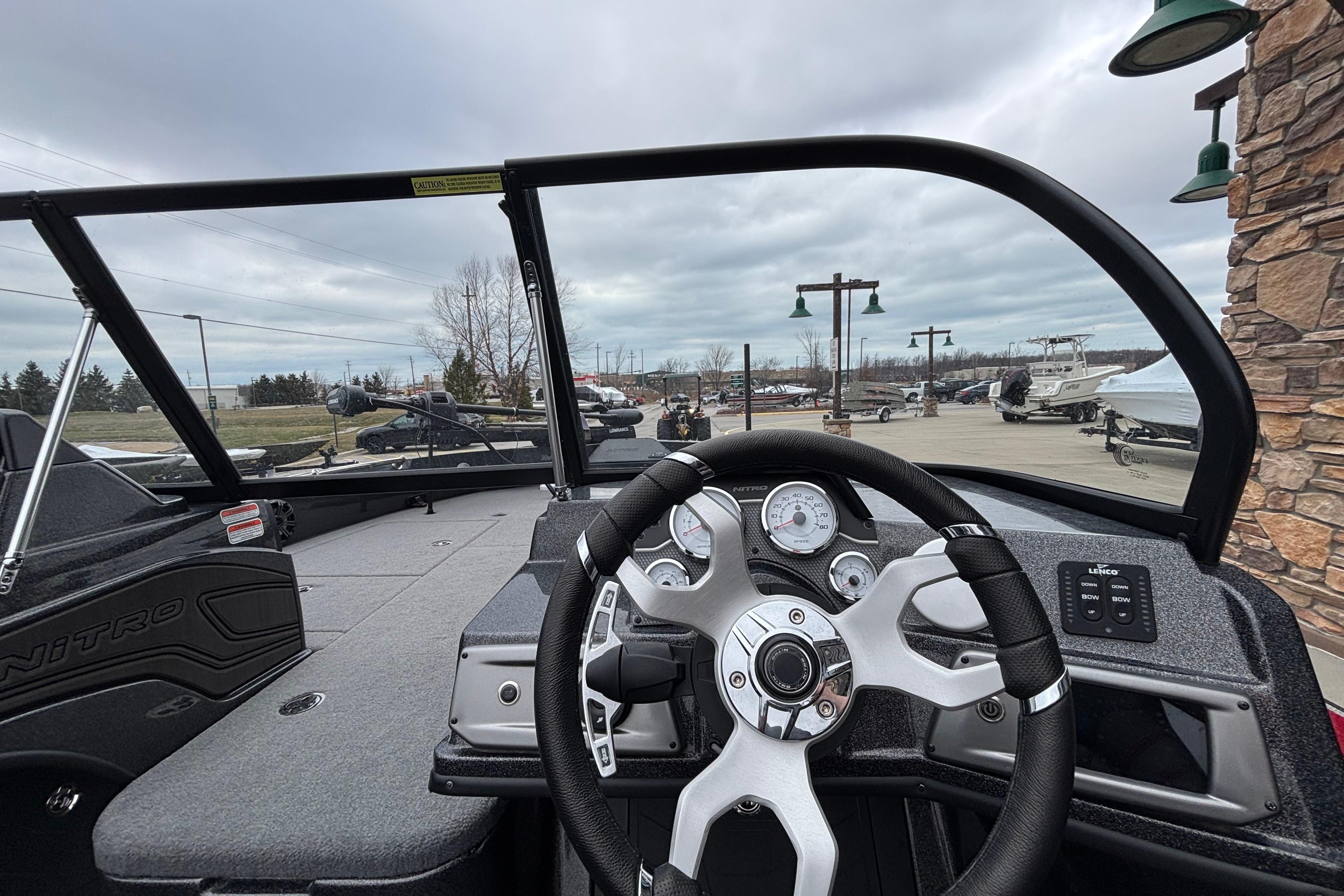 2024 Nitro ZV21 Pro boat dashboard with steering wheel and gauges, outdoor display setting.