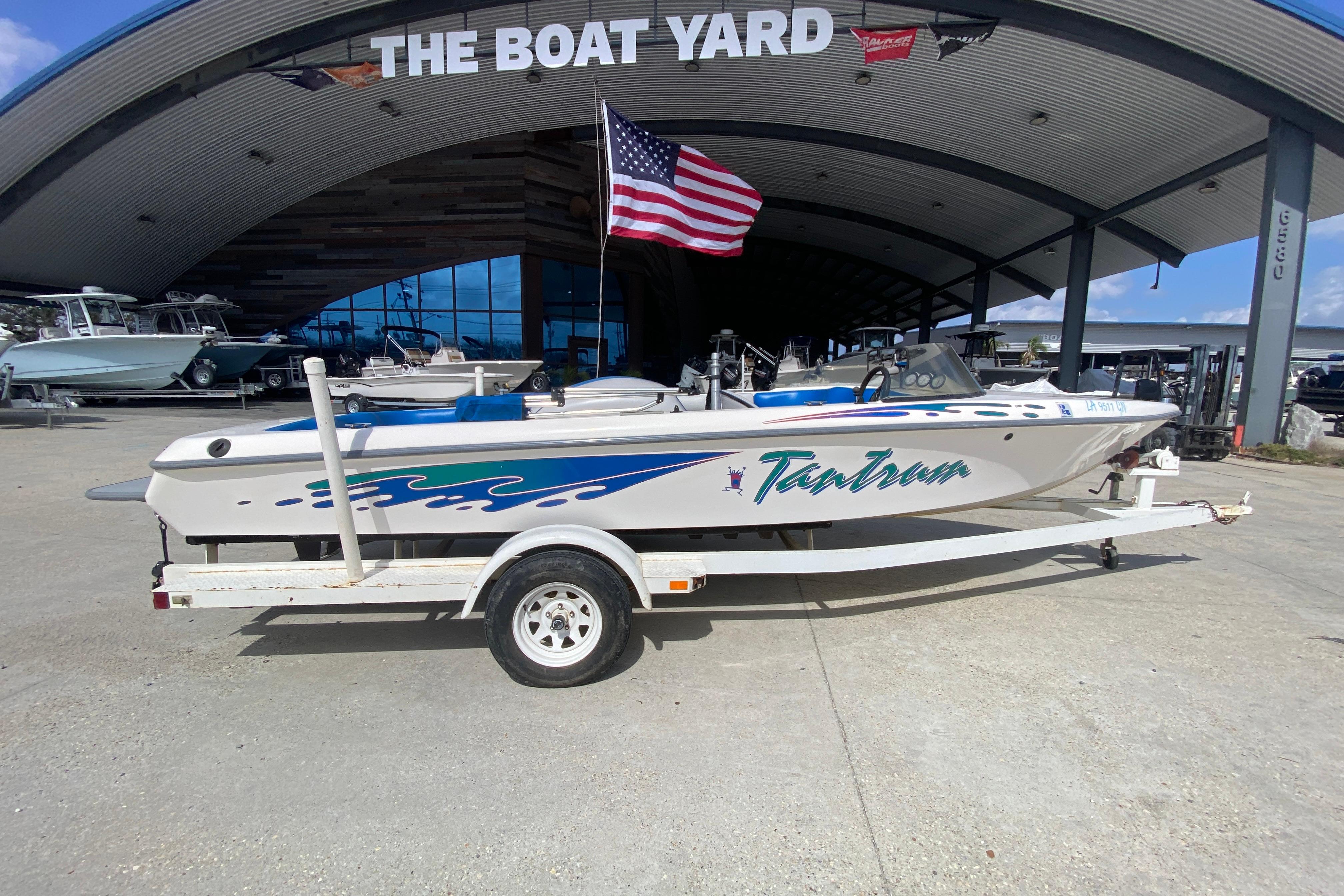 1997 Malibu Tantrum boat on trailer at The Boat Yard, American flag displayed.