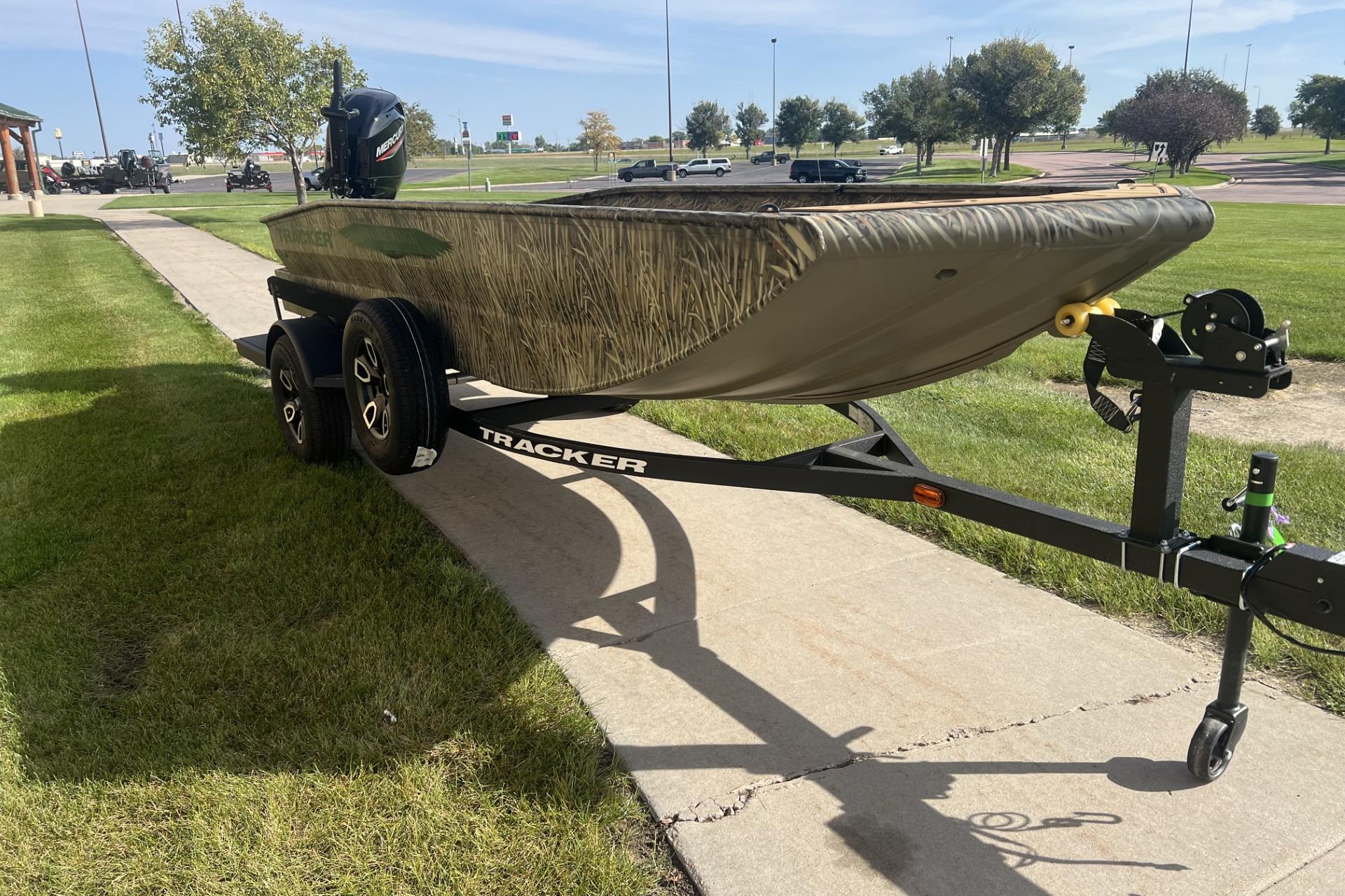 2026 Tracker Grizzly 1650 T Prairie Wings Edition boat on trailer, parked on grass.
