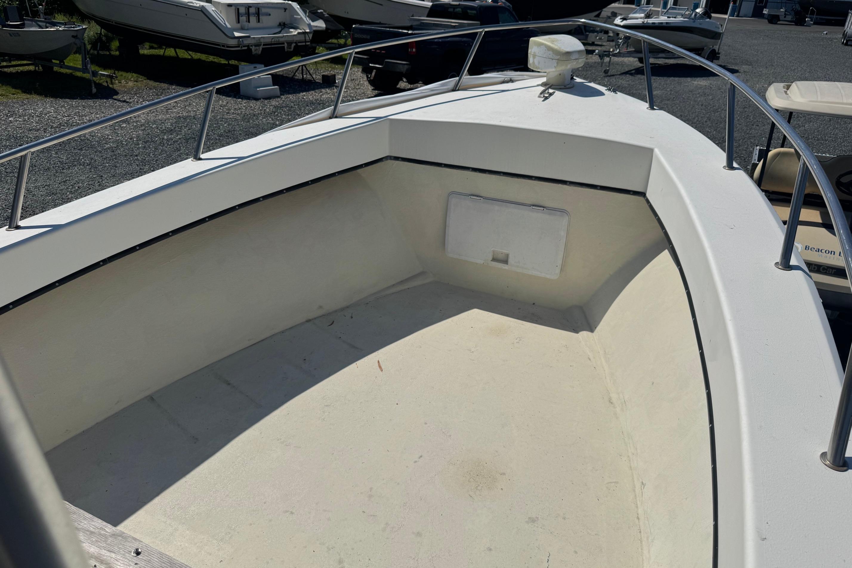 1997 Maycraft 23 boat deck with railing, parked among other boats.