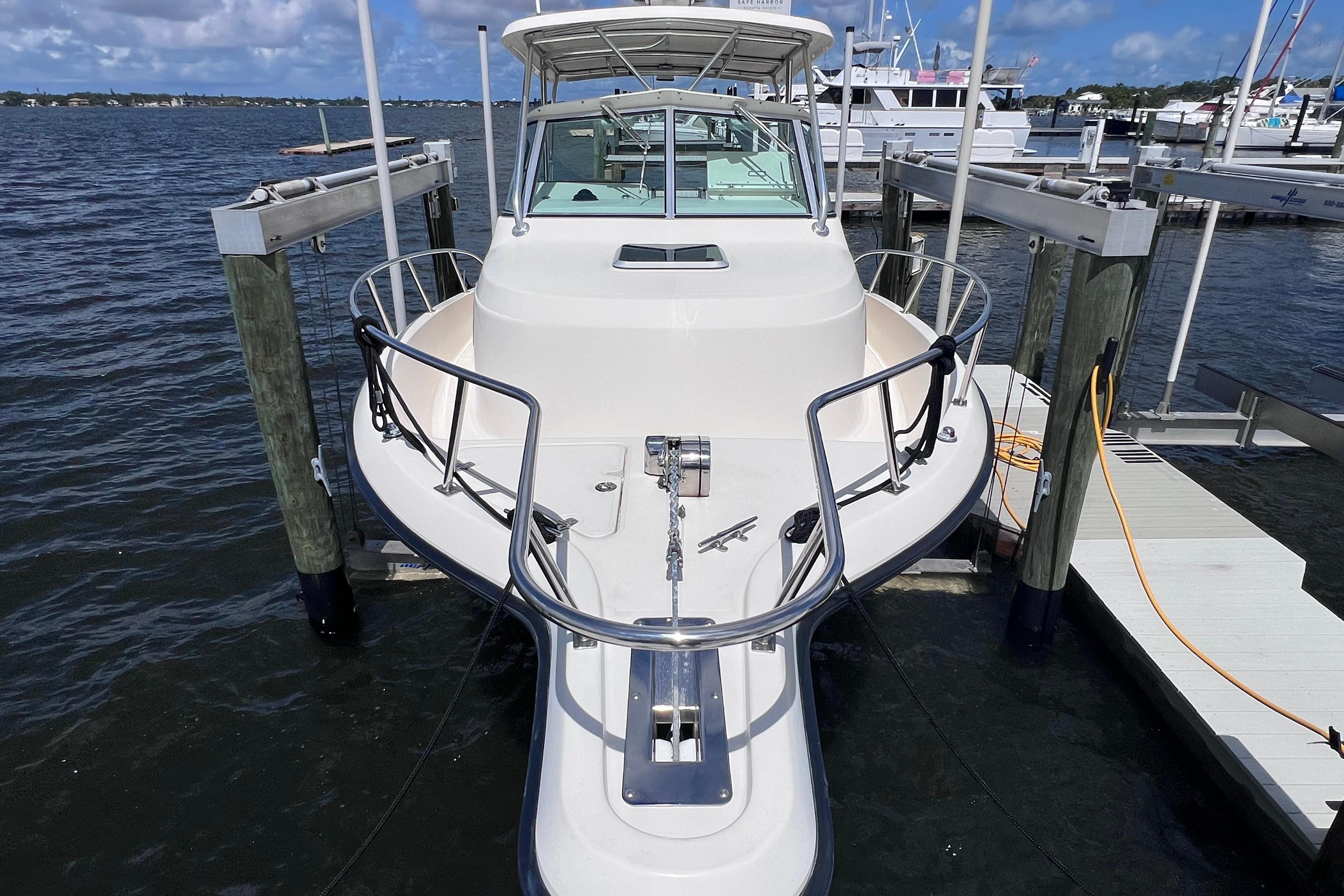 2004 Pursuit 2870 Walkaround boat docked at marina, featuring sleek design and sturdy railings.