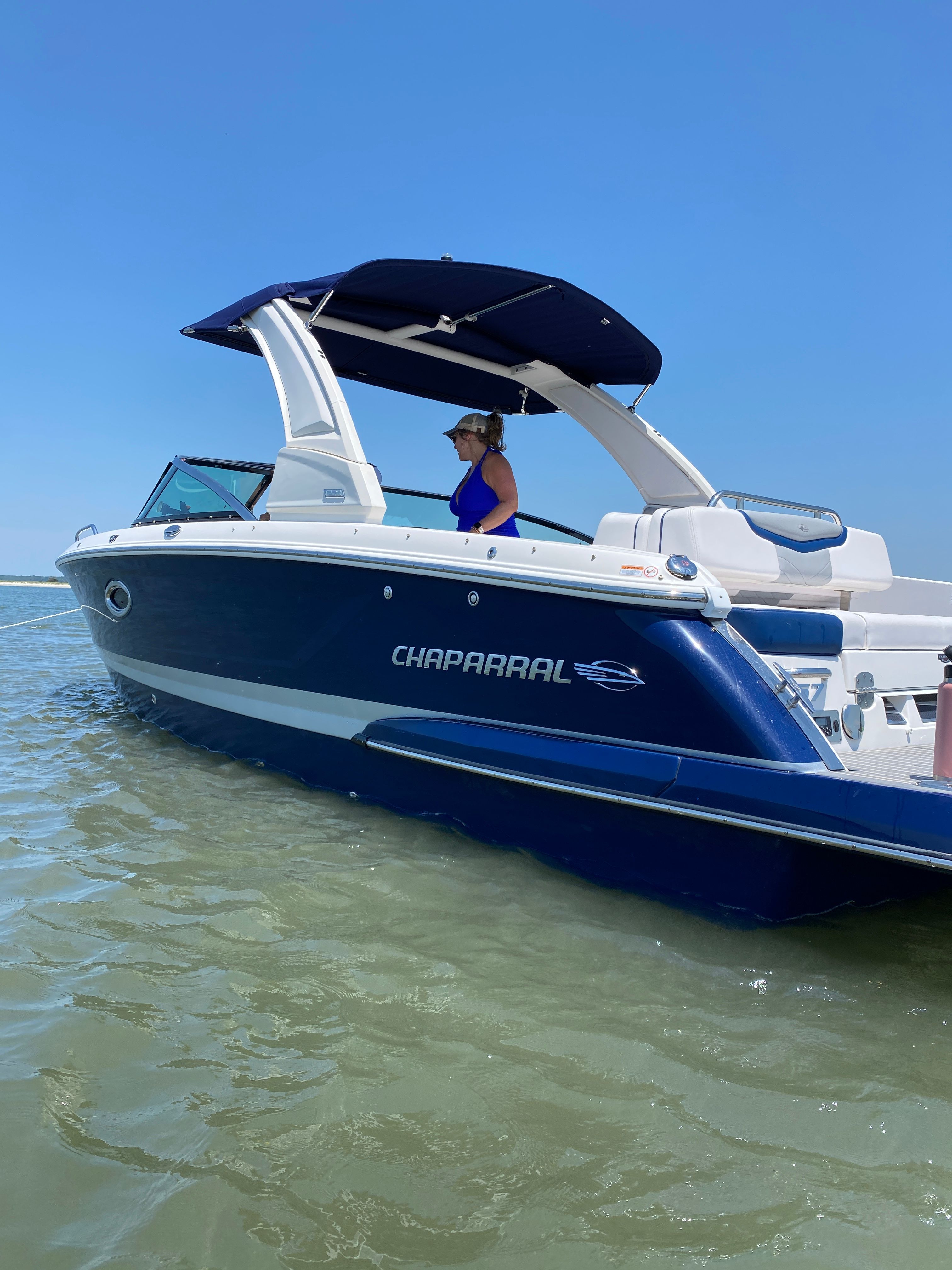 2020 Chaparral 256 SSX boat on calm water with blue sky.