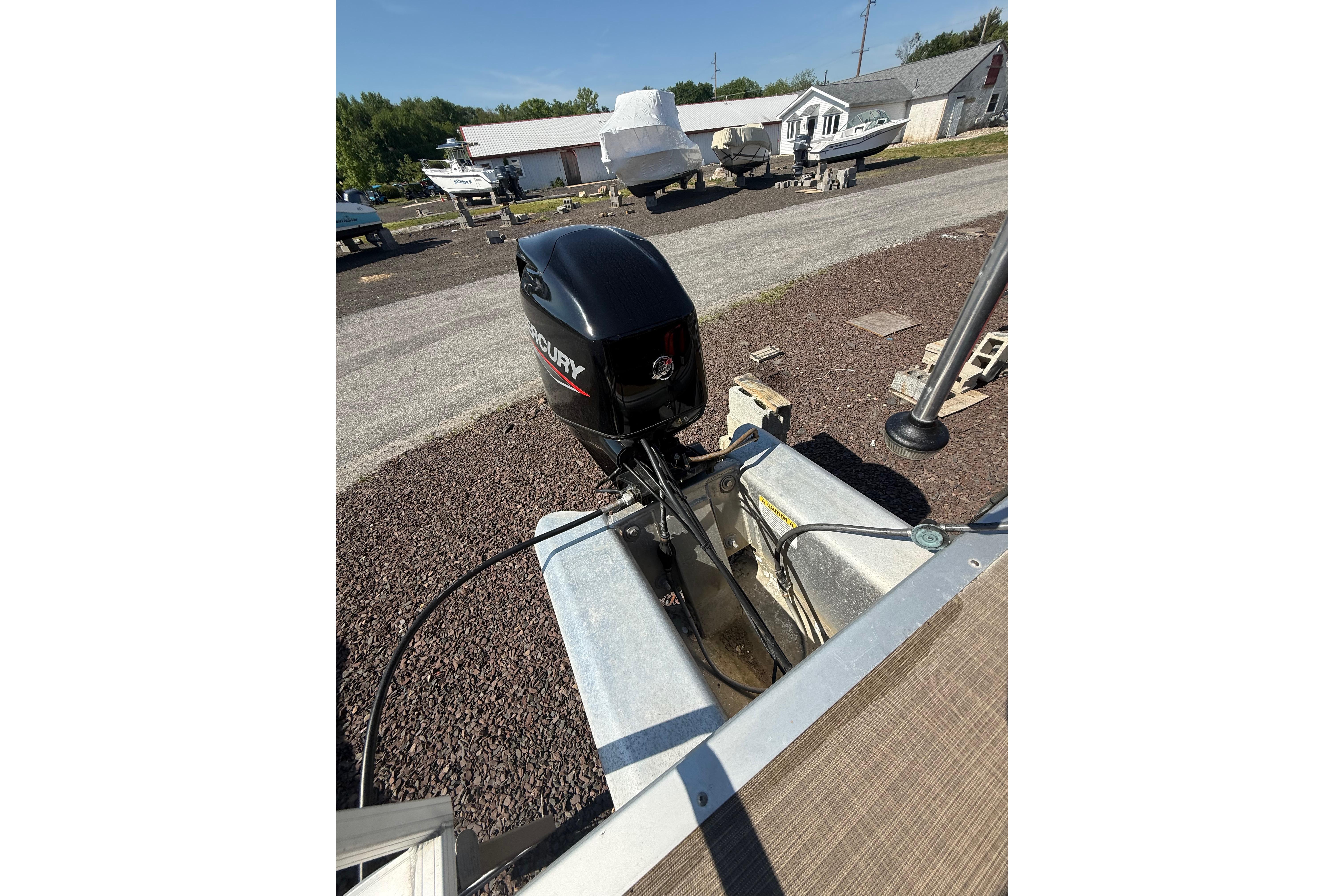 2021 Sun Tracker Bass Buggy 16 XL Select with Mercury outboard motor in a boatyard.