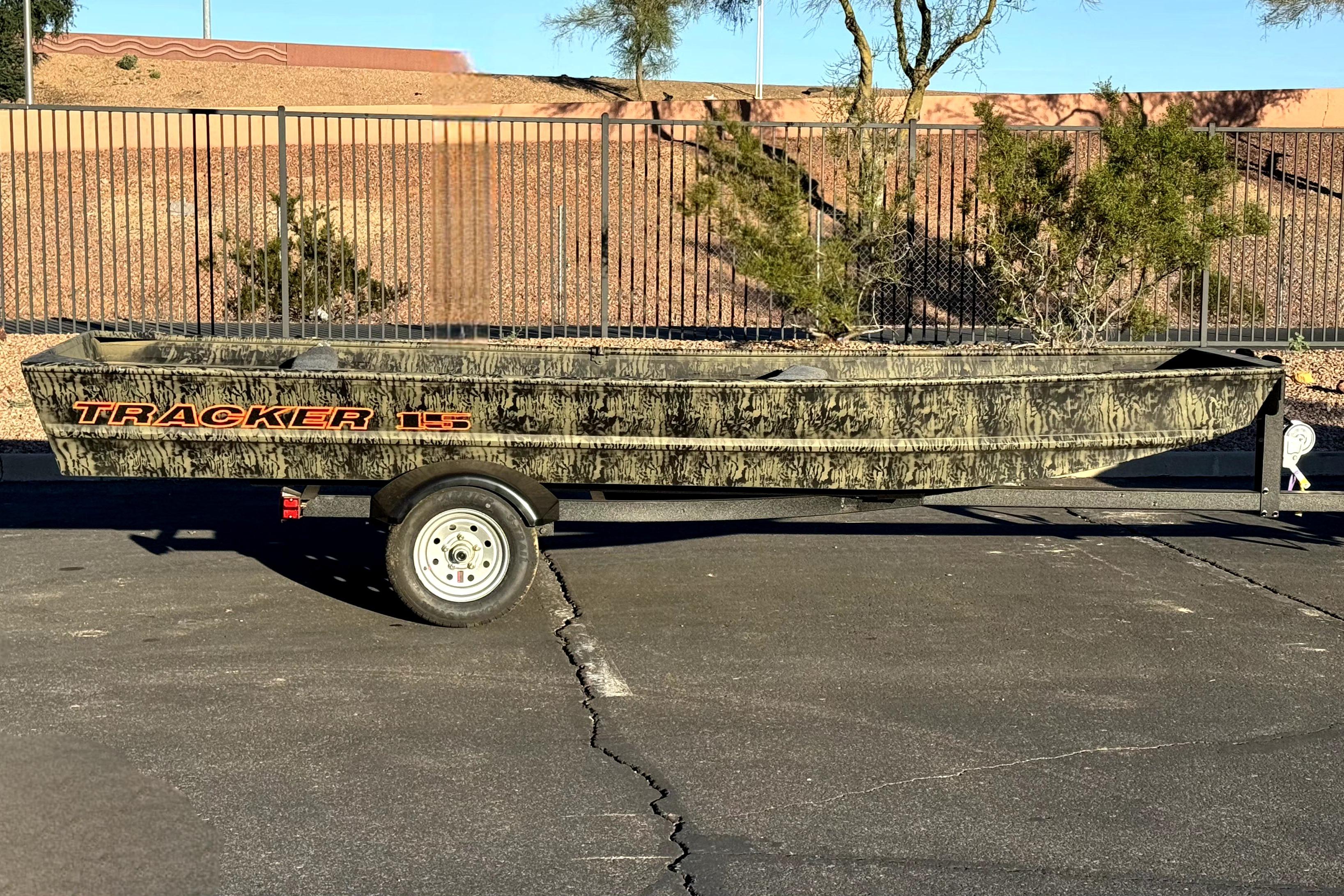 2026 Tracker Grizzly 15 Jon boat on trailer, parked outdoors.