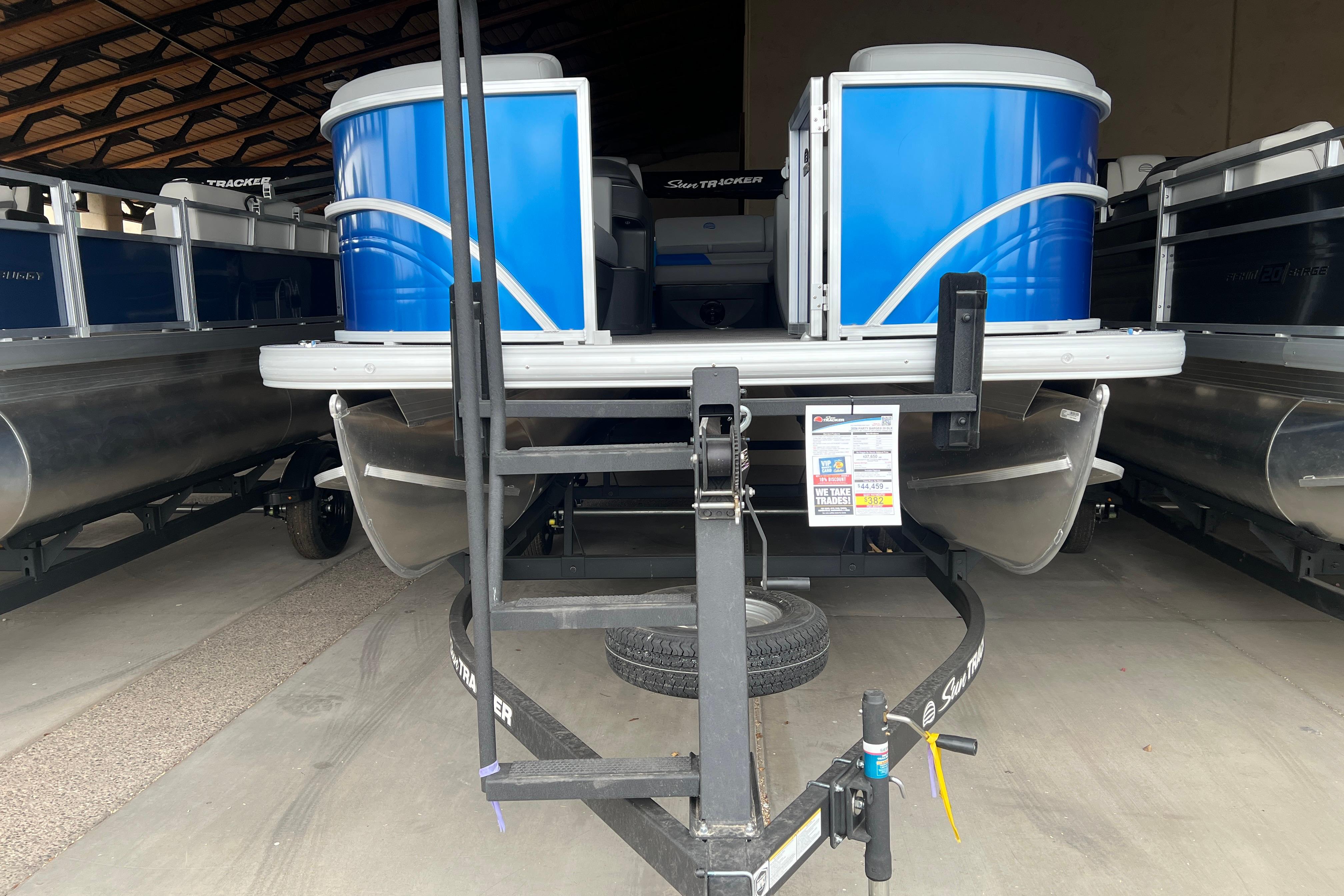 2026 Sun Tracker Party Barge 20 DLX pontoon boat in storage facility.