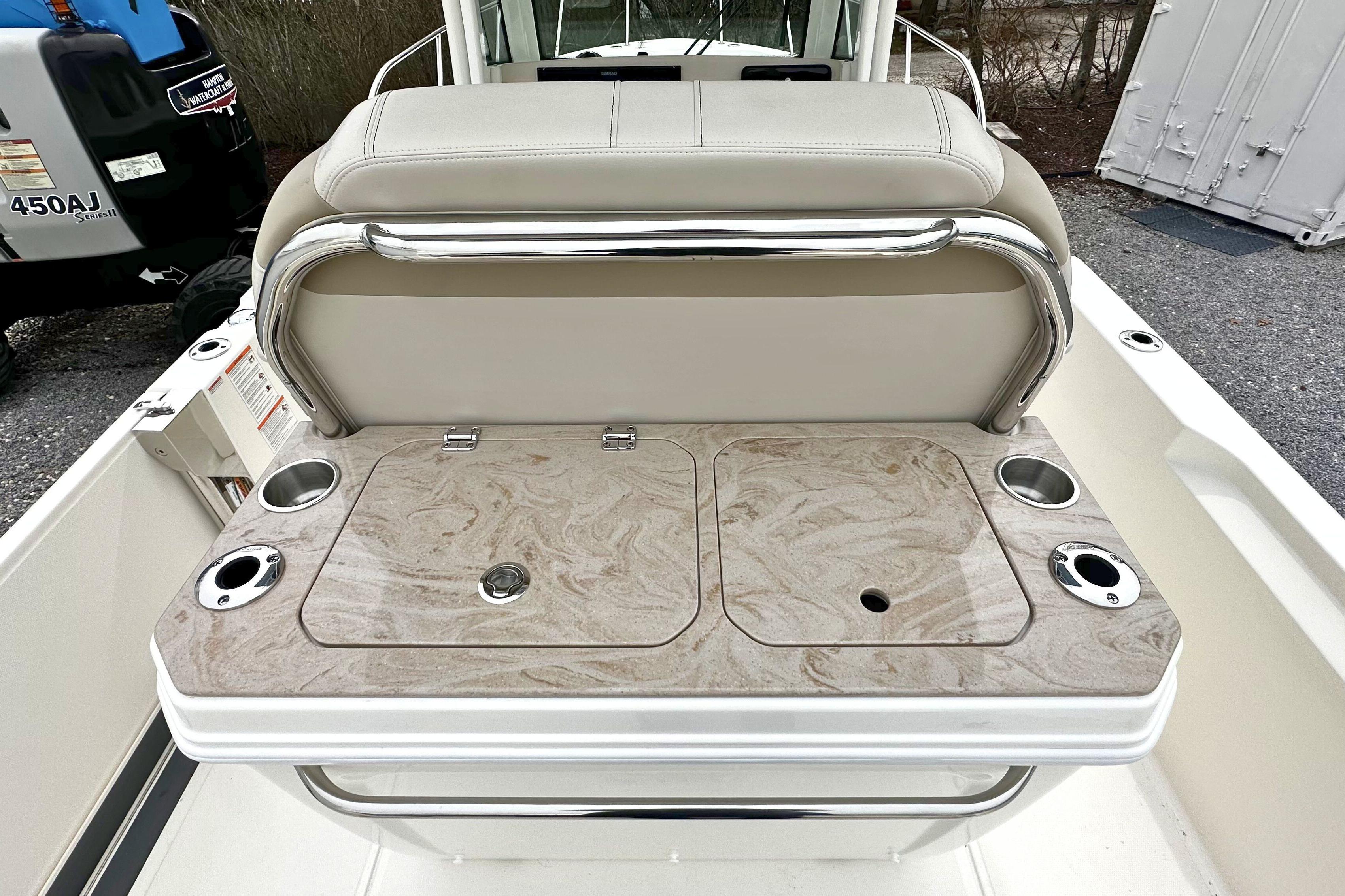 2026 Boston Whaler 280 Dauntless boat seating area with storage compartments and cup holders.