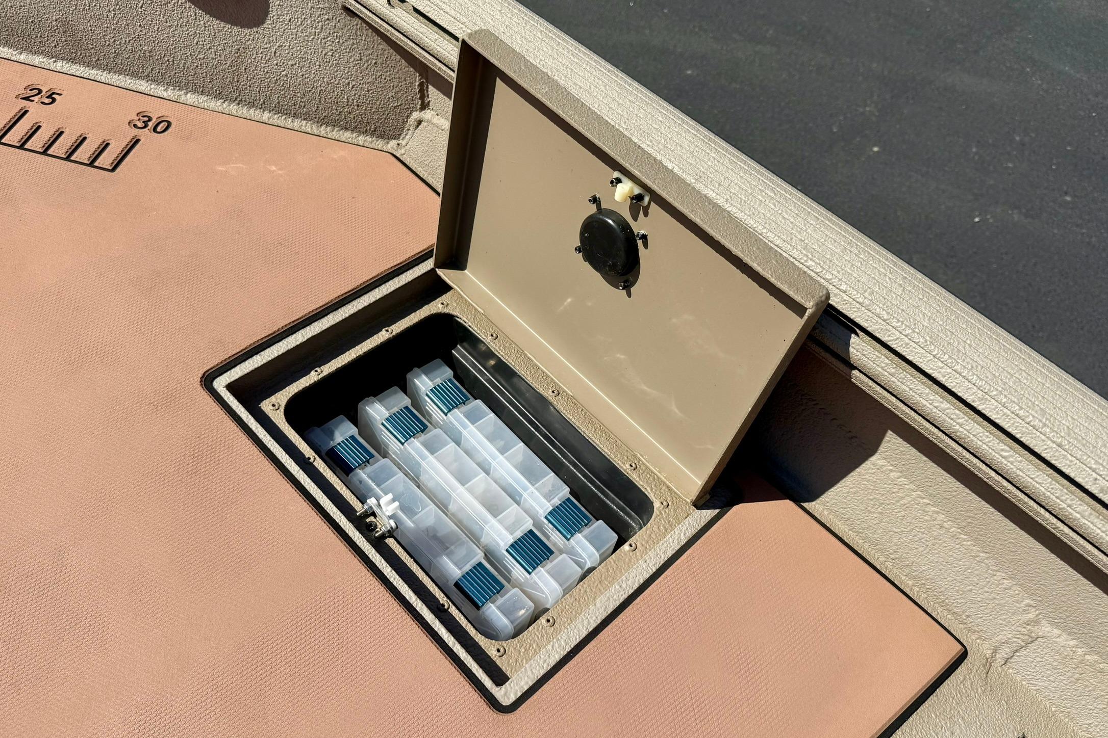 Storage compartment on 2019 Excel 230 Bay Pro boat with organized tackle boxes.