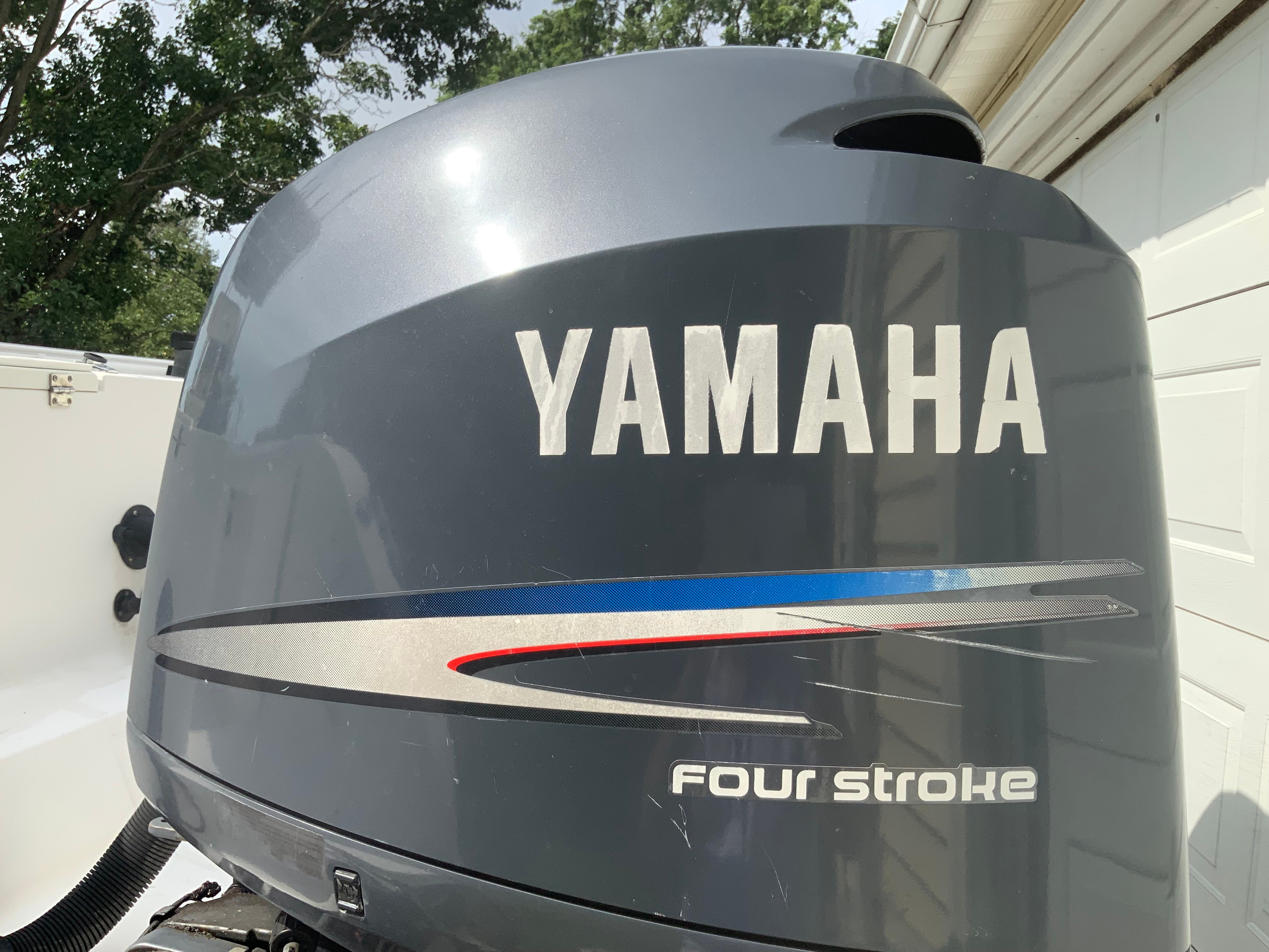 Yamaha outboard motor on a boat, labeled "Four Stroke," next to a garage.