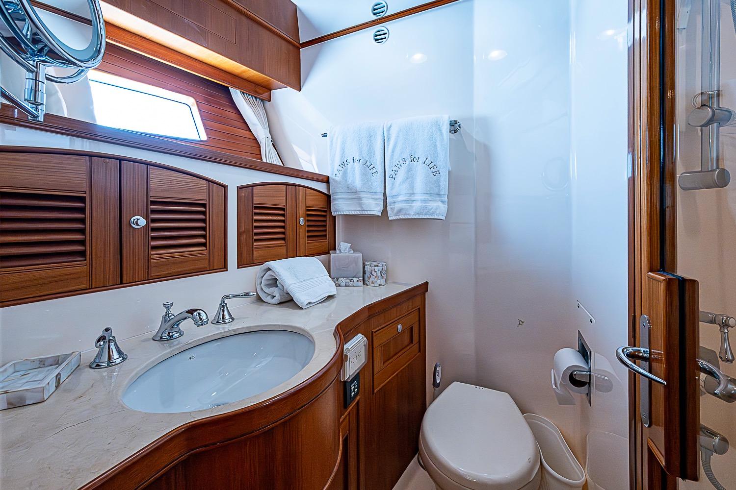 Luxurious bathroom in 2014 Marlow 80 Explorer yacht with elegant wood cabinetry.