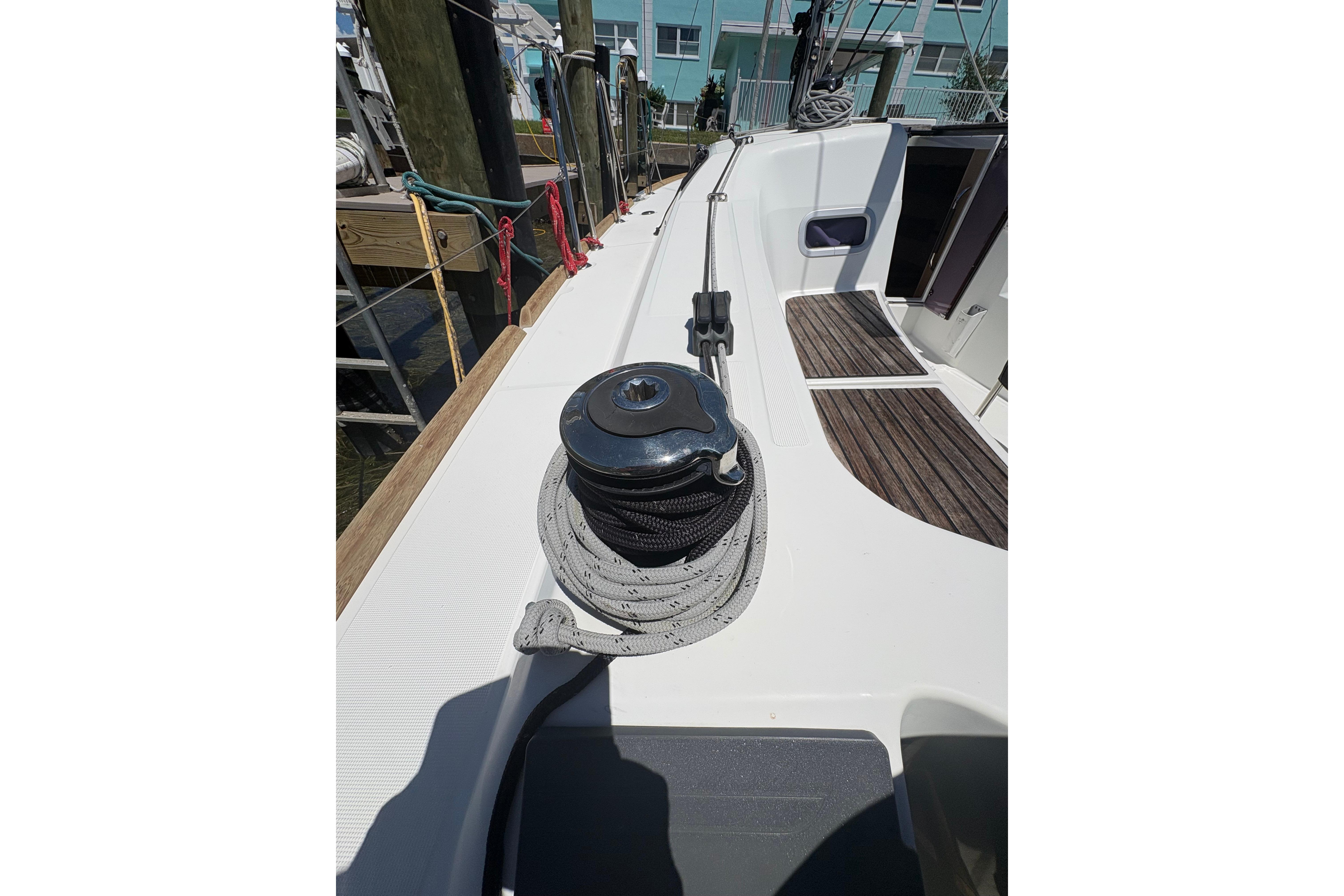 Deck view of 2021 Jeanneau Sun Odyssey 349 sailboat, featuring winch and teak flooring.