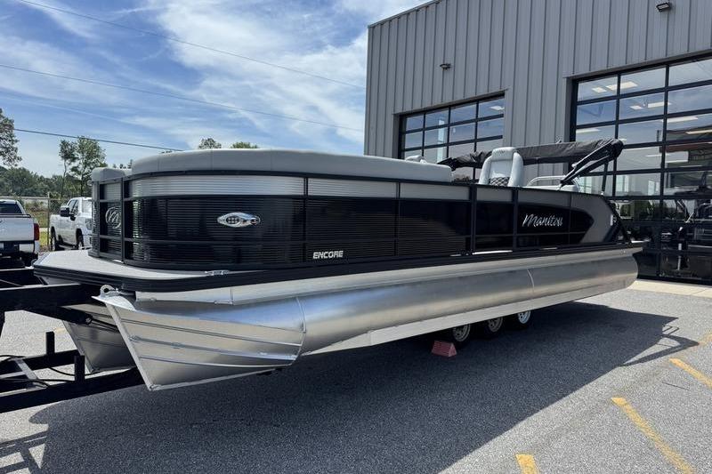 2026 Manitou Encore 25 SL SHP pontoon boat parked outside a building.