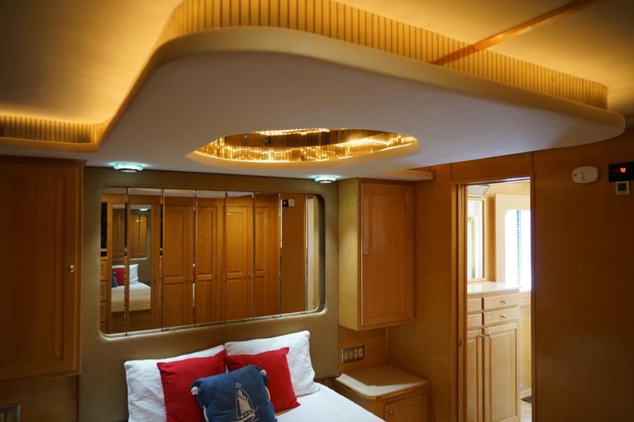 Luxurious bedroom interior of 2000 Stardust Cruisers houseboat, featuring elegant wood paneling and ambient lighting.