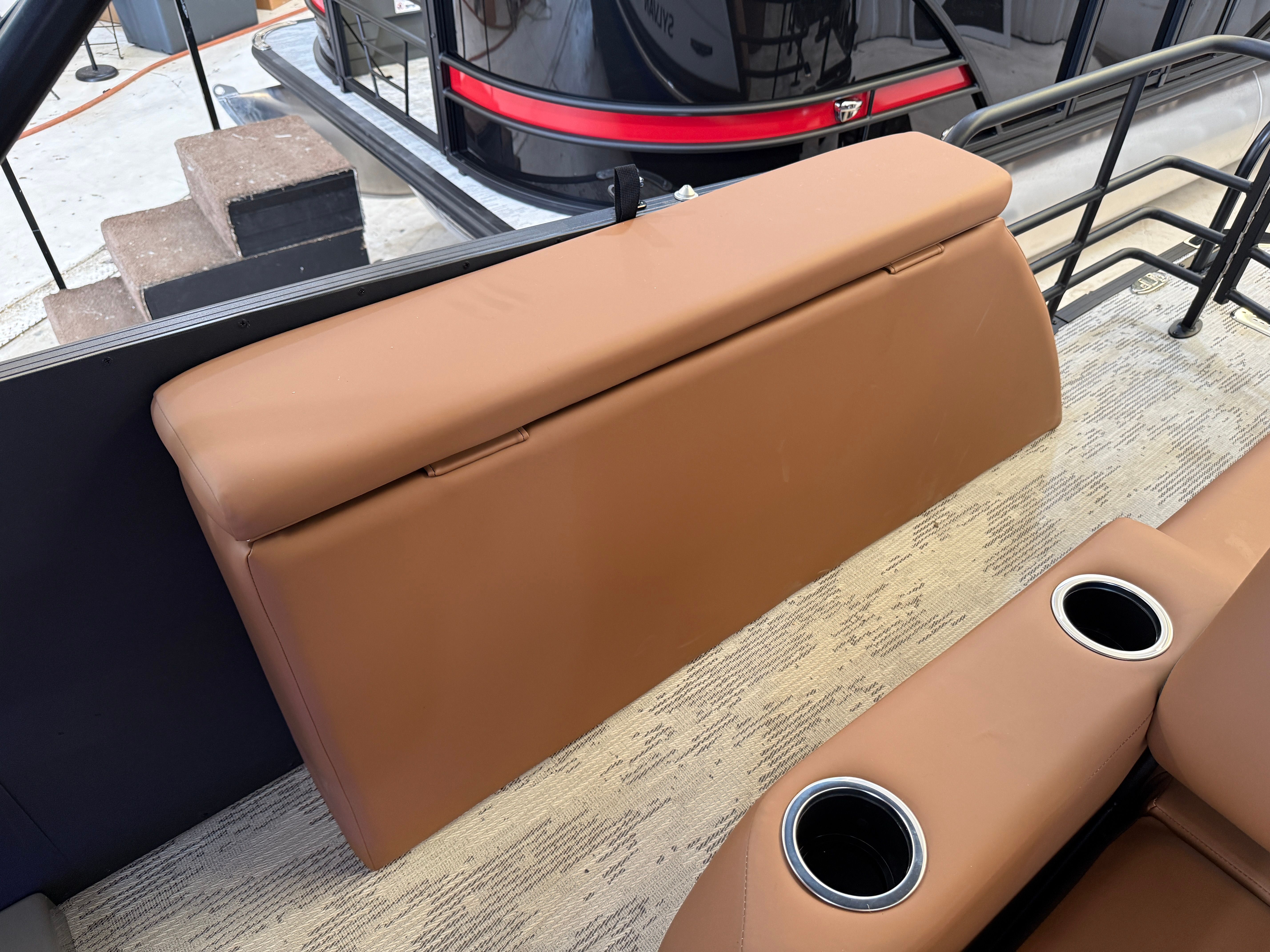 The image shows a brown bench seat with cup holders on a boat.