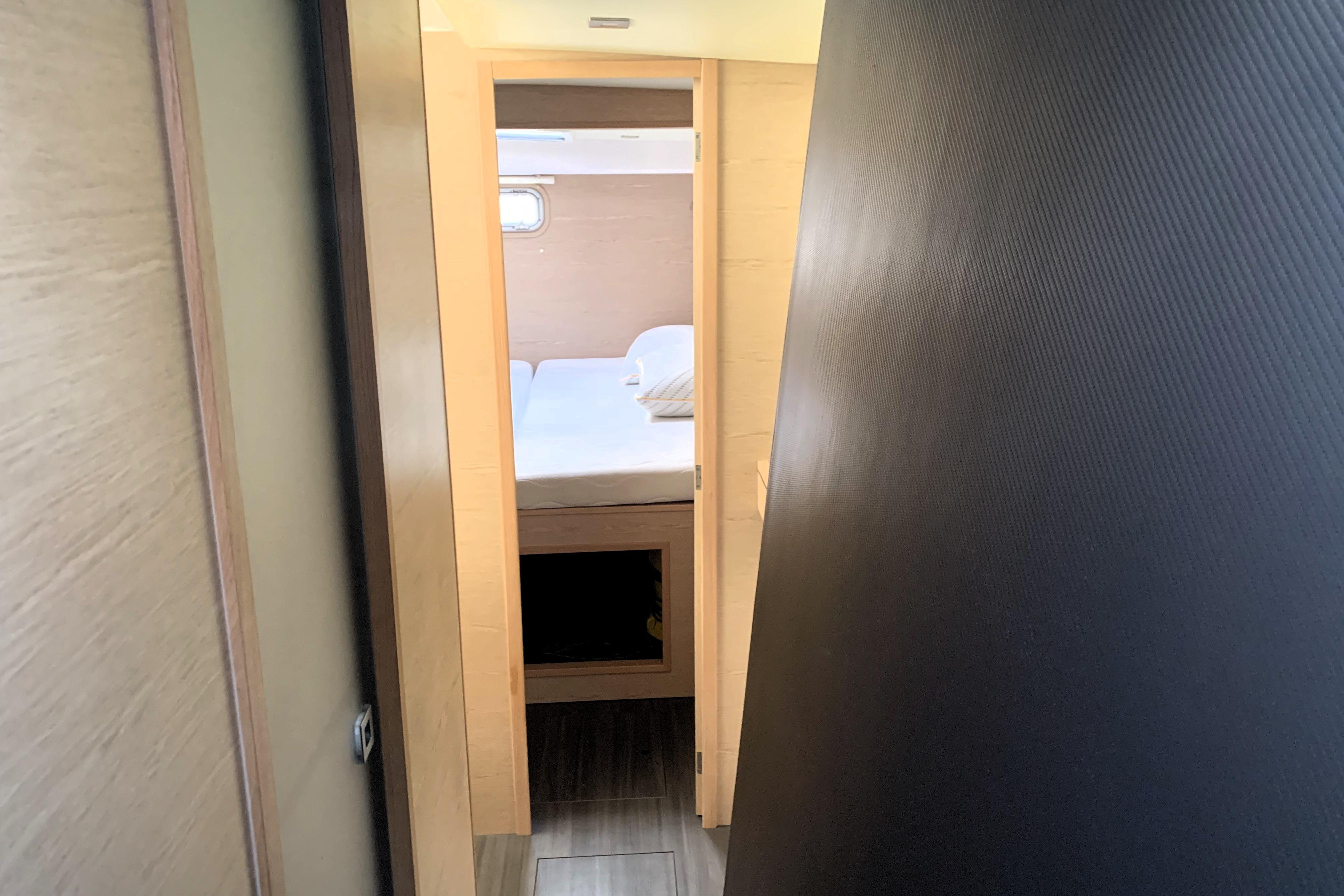 Interior view of 2024 Outremer 45 yacht cabin with bed and window.