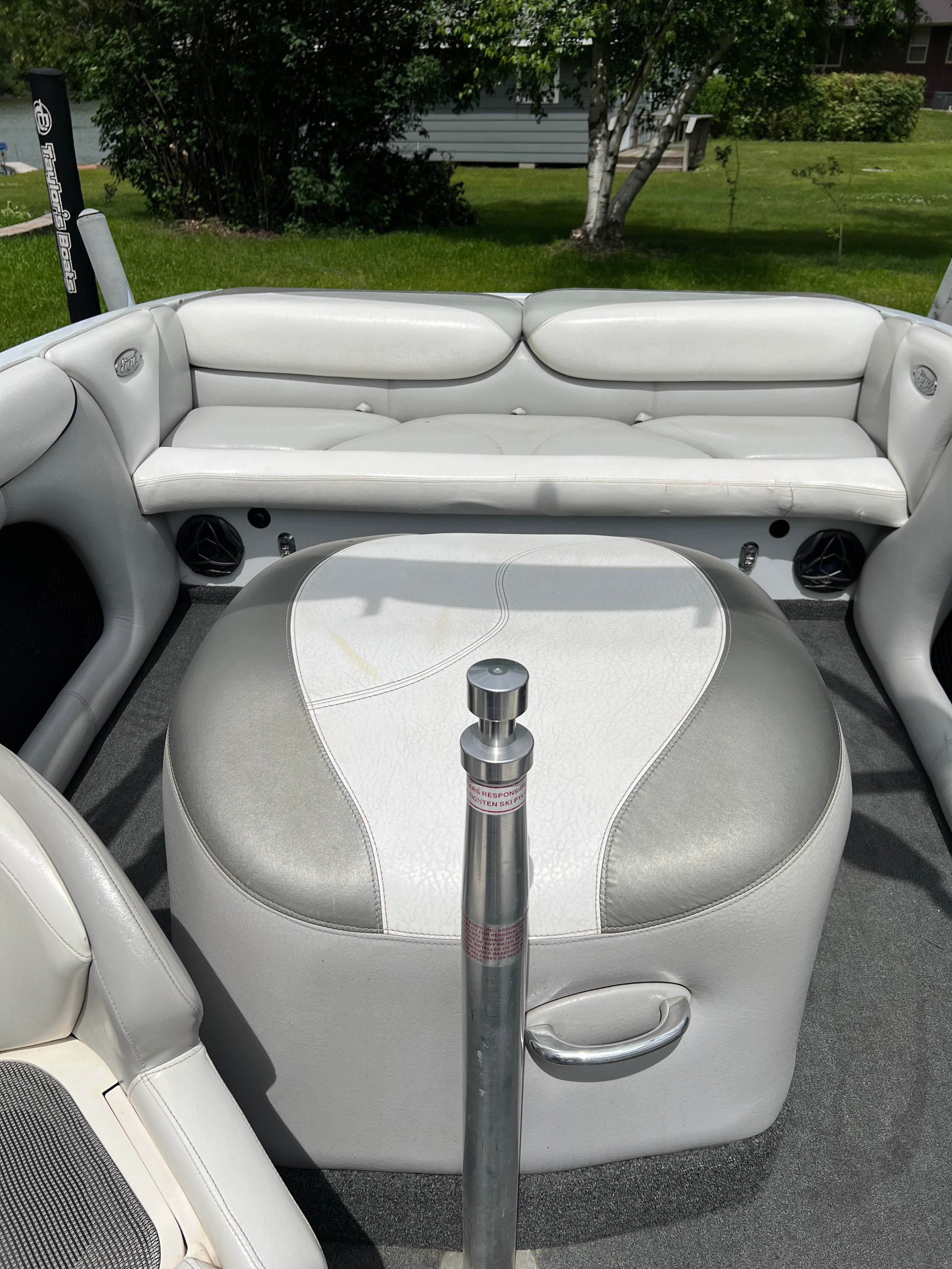 Interior of a 2006 Tigé 20i with gray and white upholstery and a central pole.