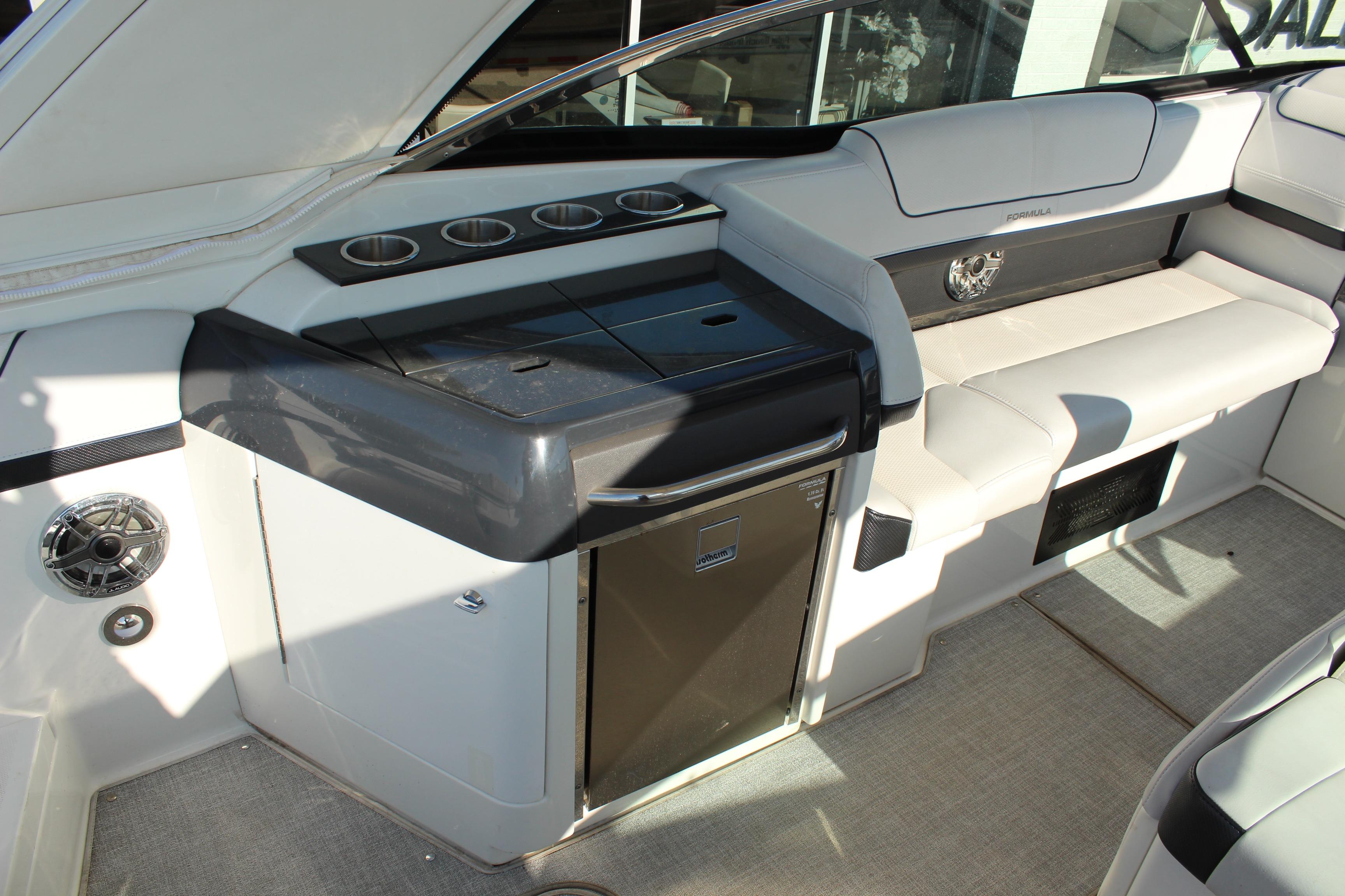 2023 Formula 310 Bowrider I/O interior with seating, cup holders, and a compact fridge.